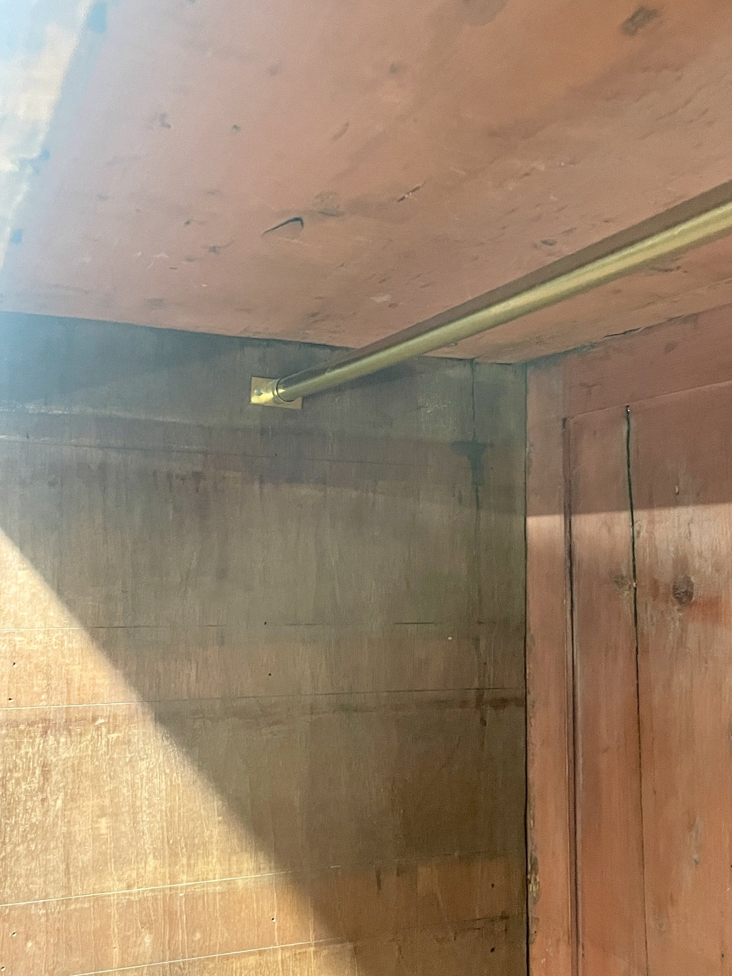 Wooden cabinet with a gold handle on a wooden wall.