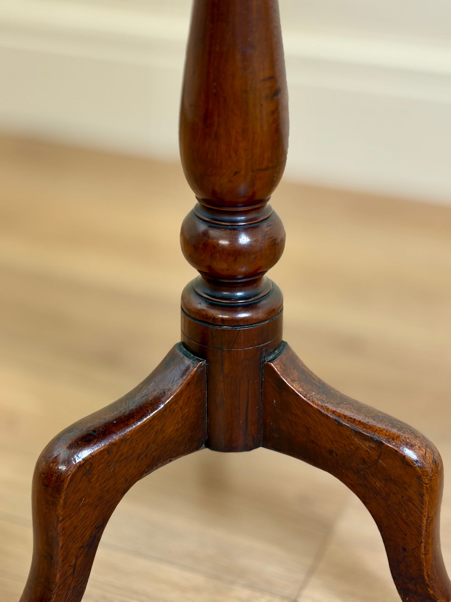 Close-up of a wooden chair leg with a beige background