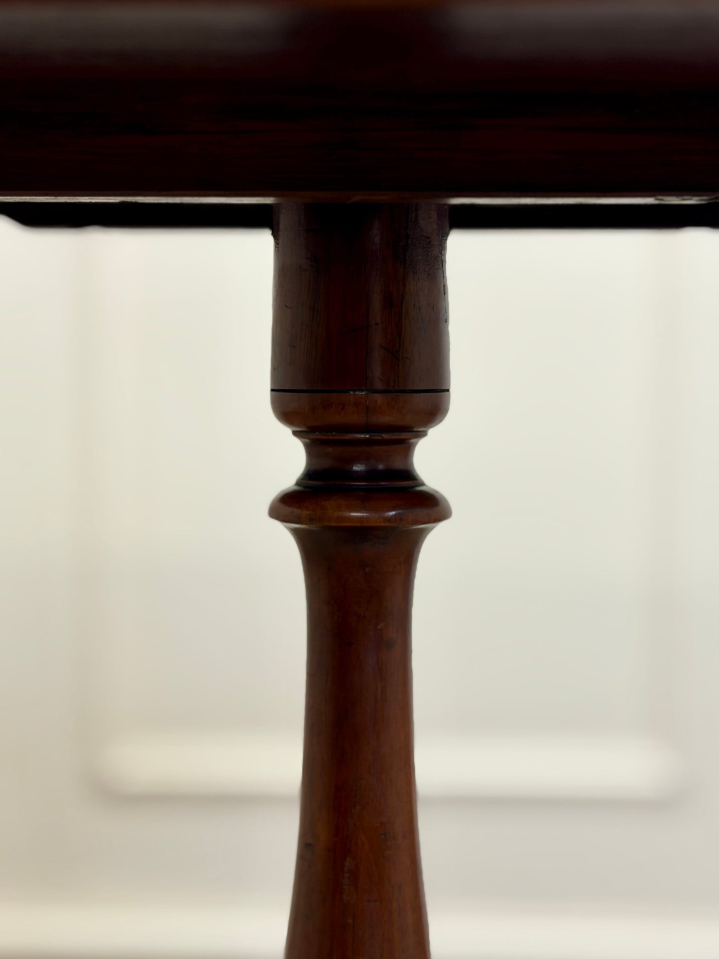 Close-up of a wooden table leg on a white background