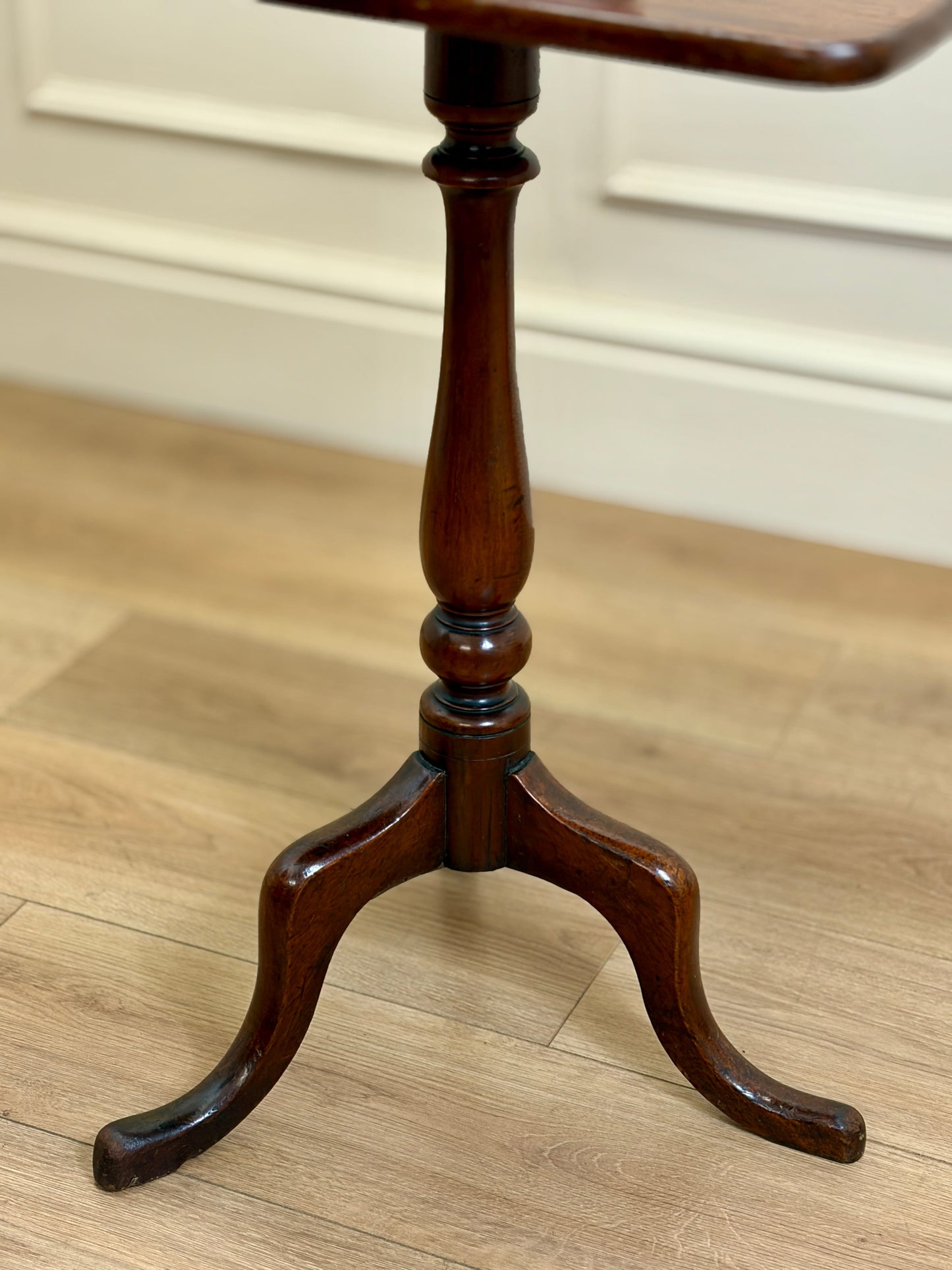 Wooden table with a pedestal base on a wooden floor