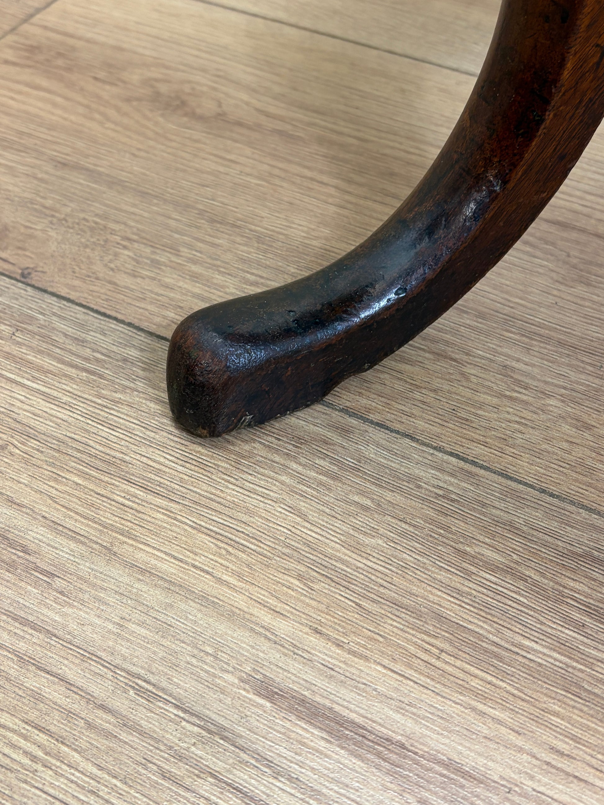 Close-up of a wooden chair leg on a wooden floor