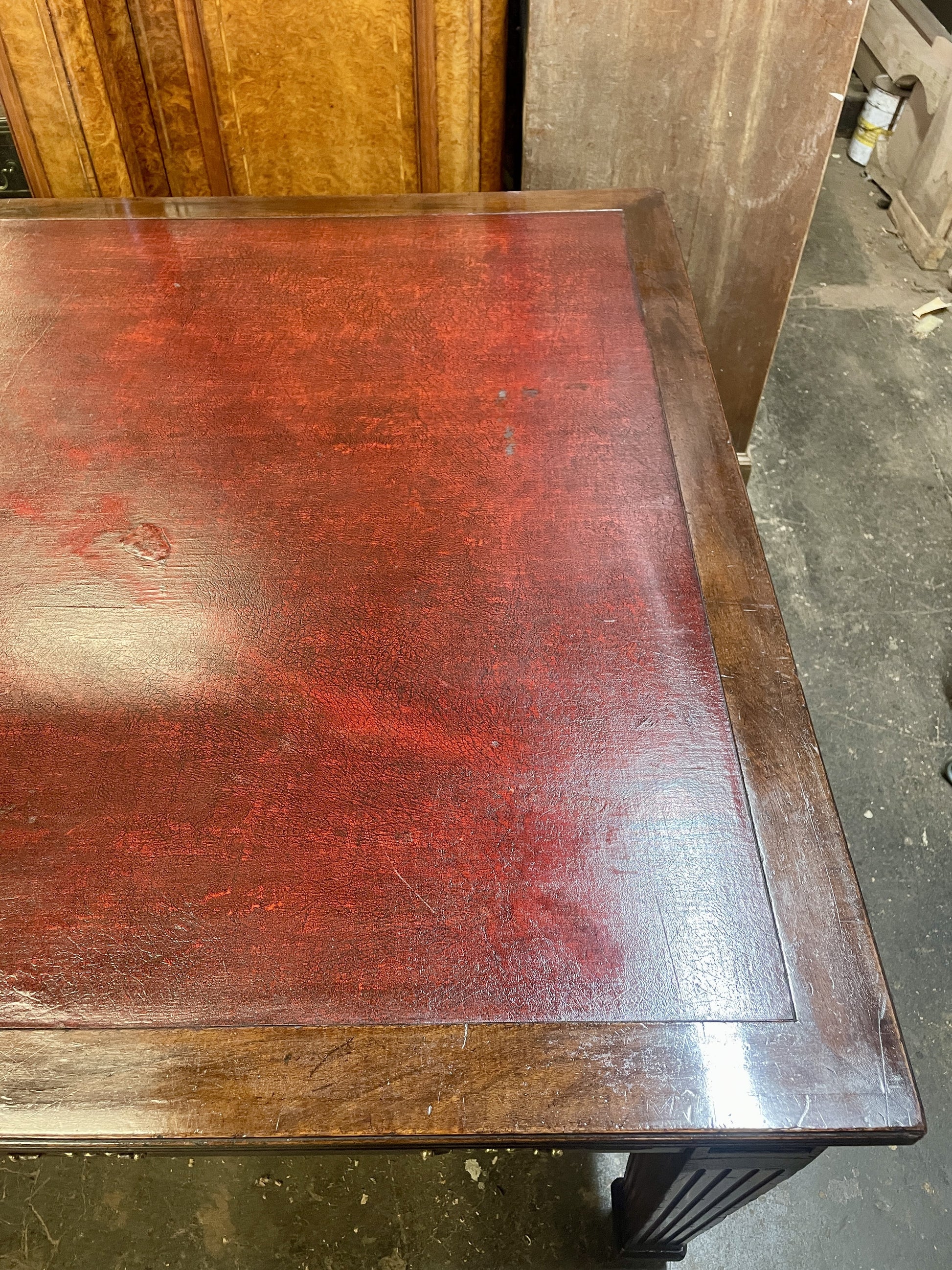 Wooden desk with a red-brown finish in an indoor setting