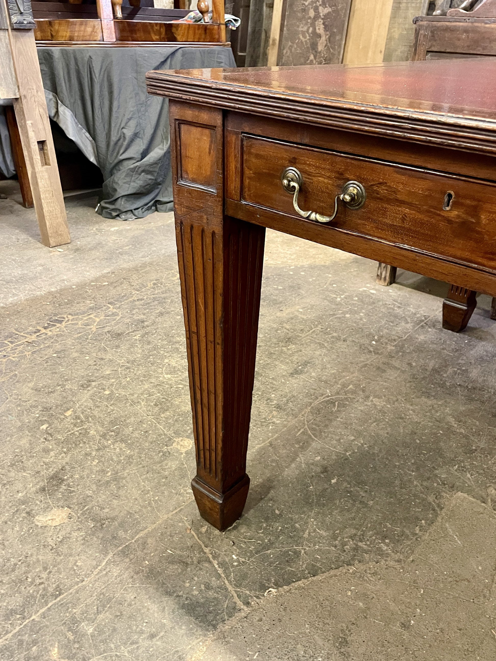 Wooden desk with a drawer on a stone floor