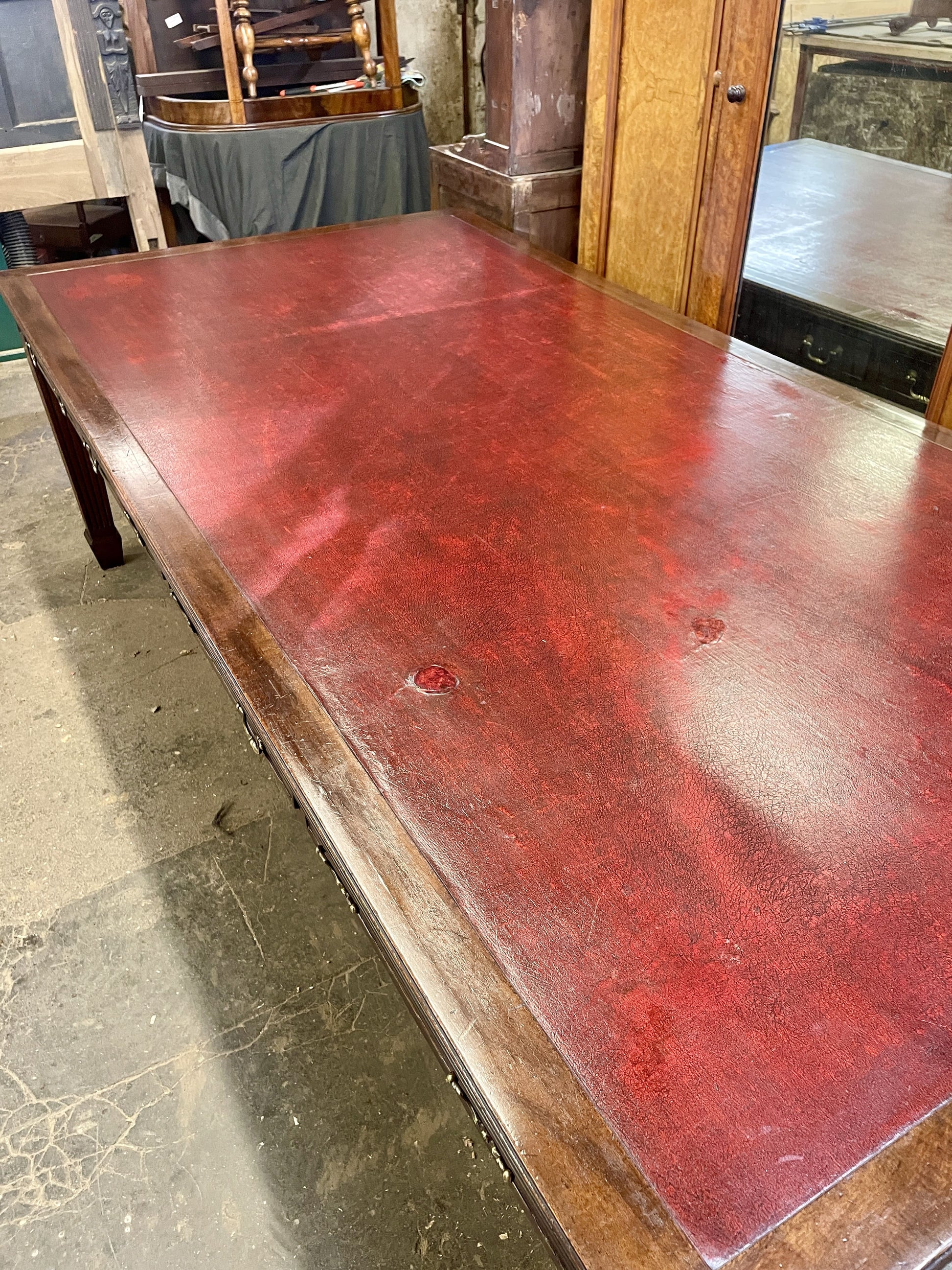 Large wooden table with a red-brown finish in an indoor setting