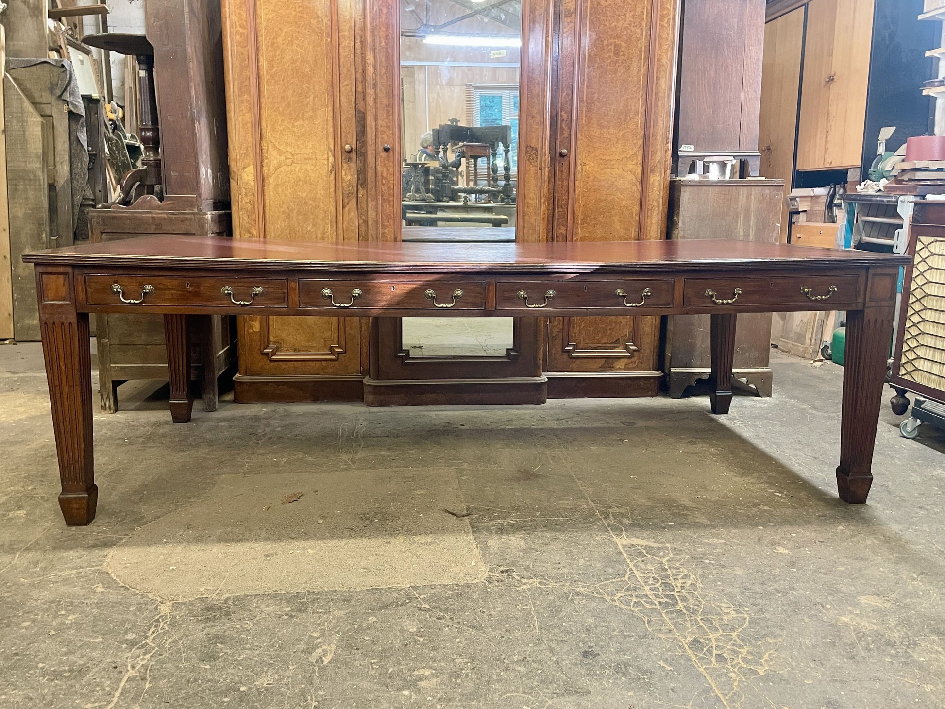 Large wooden dining table in a storage or warehouse setting