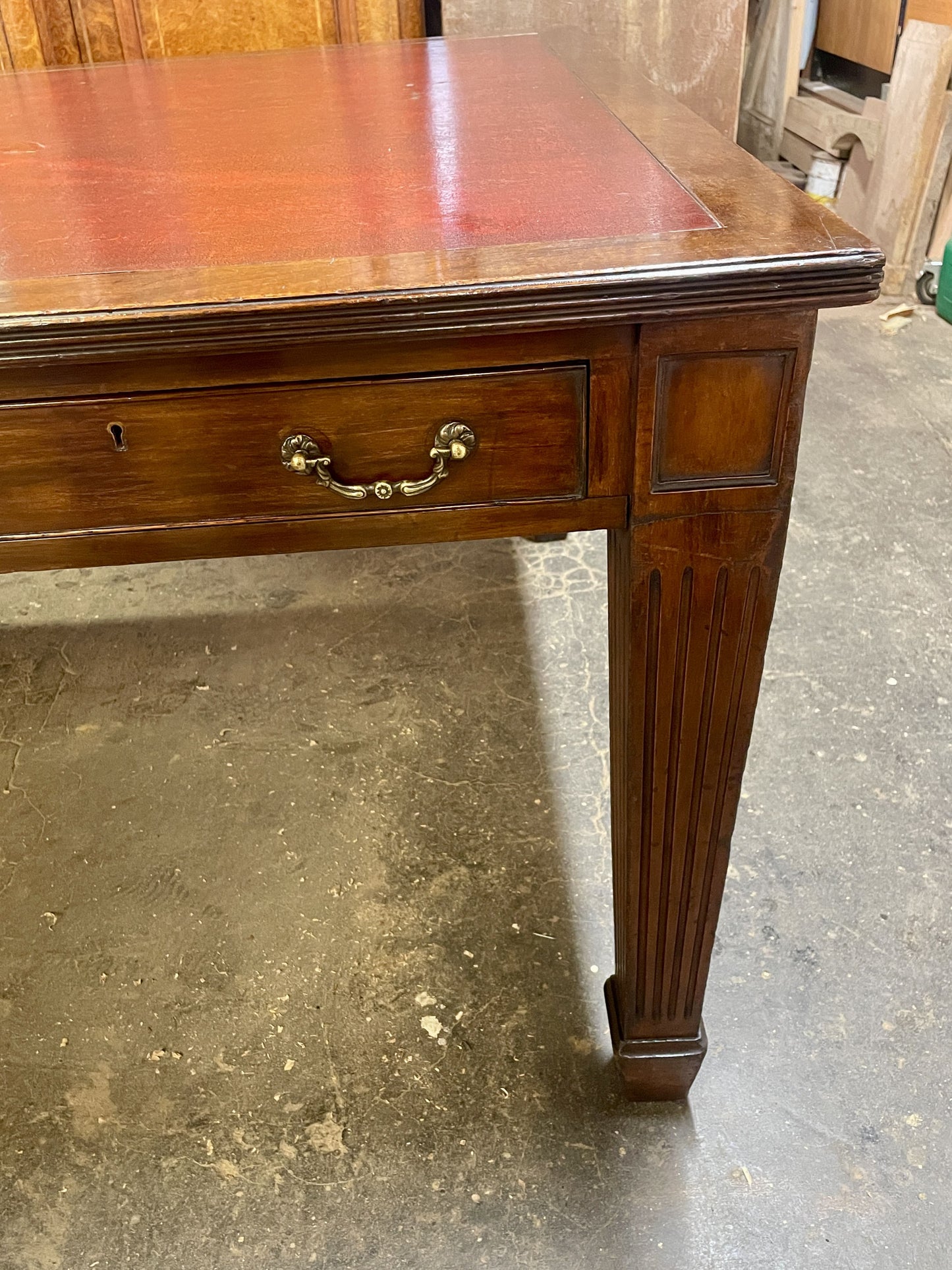 Wooden desk with a single drawer on a concrete floor