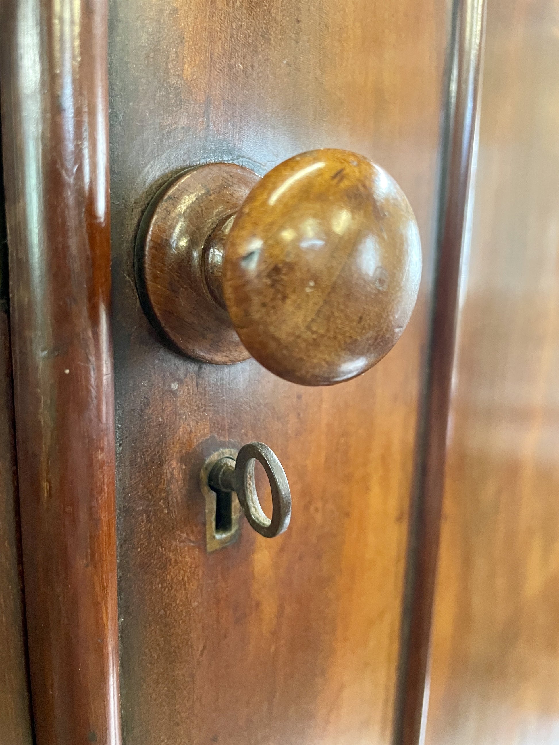Close-up of a wooden door with a brass doorknob and keyhole.