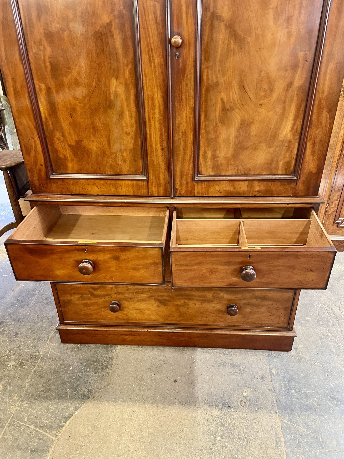 Wooden wardrobe with open drawers on a concrete floor
