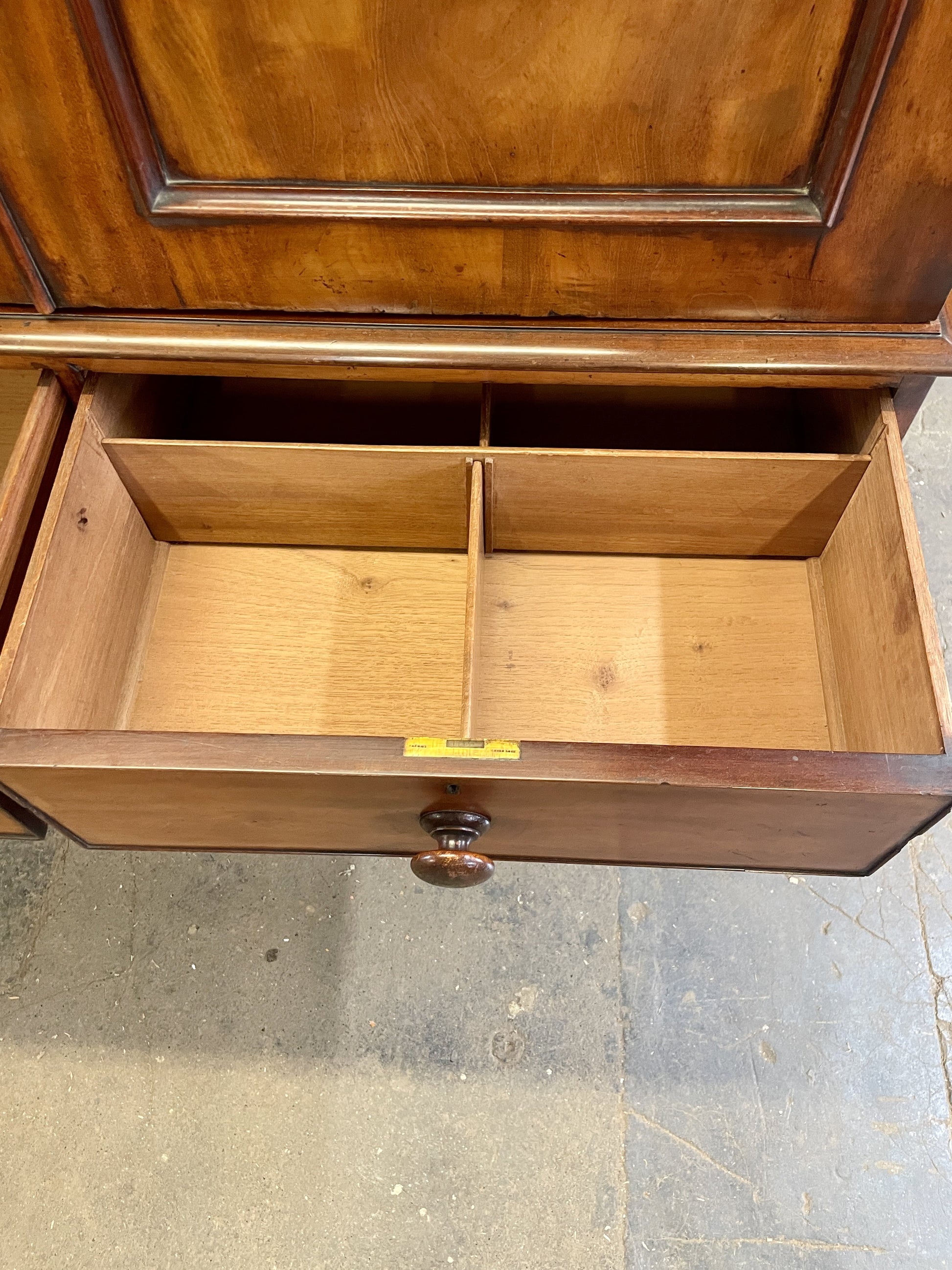 Wooden cabinet with open doors on a concrete floor