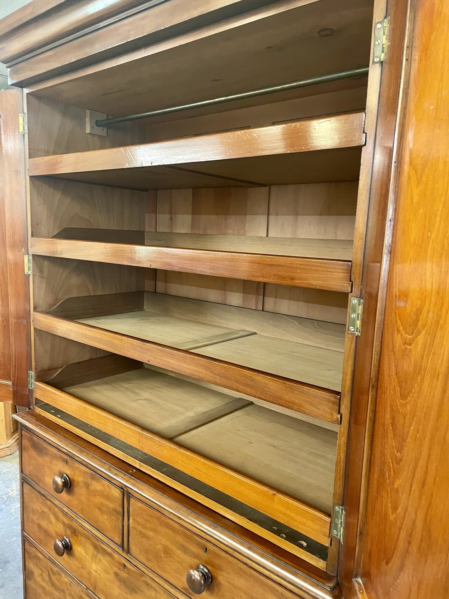 Wooden cabinet with open doors revealing empty shelves.