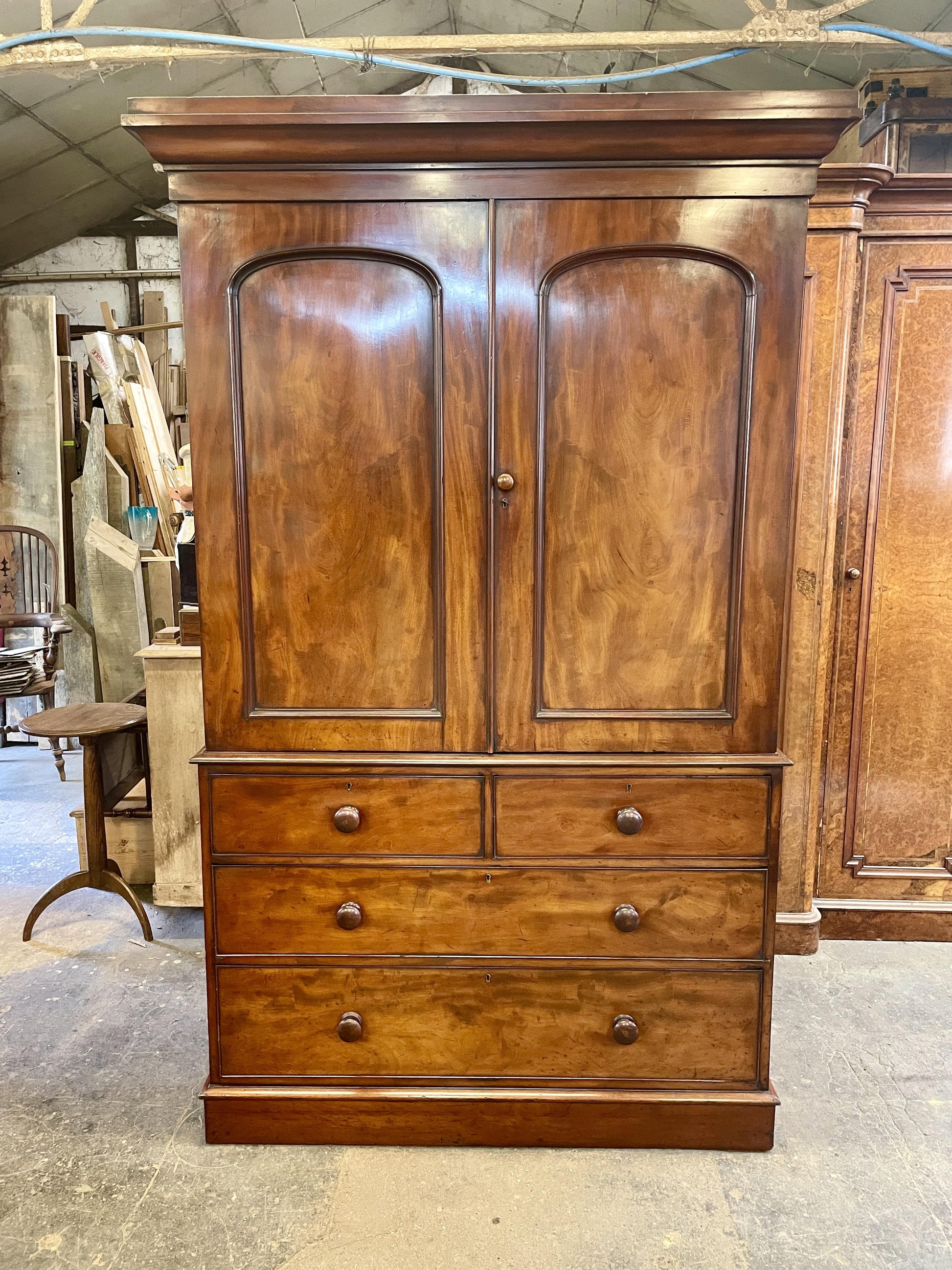 Wooden wardrobe with two doors and three drawers in a workshop setting