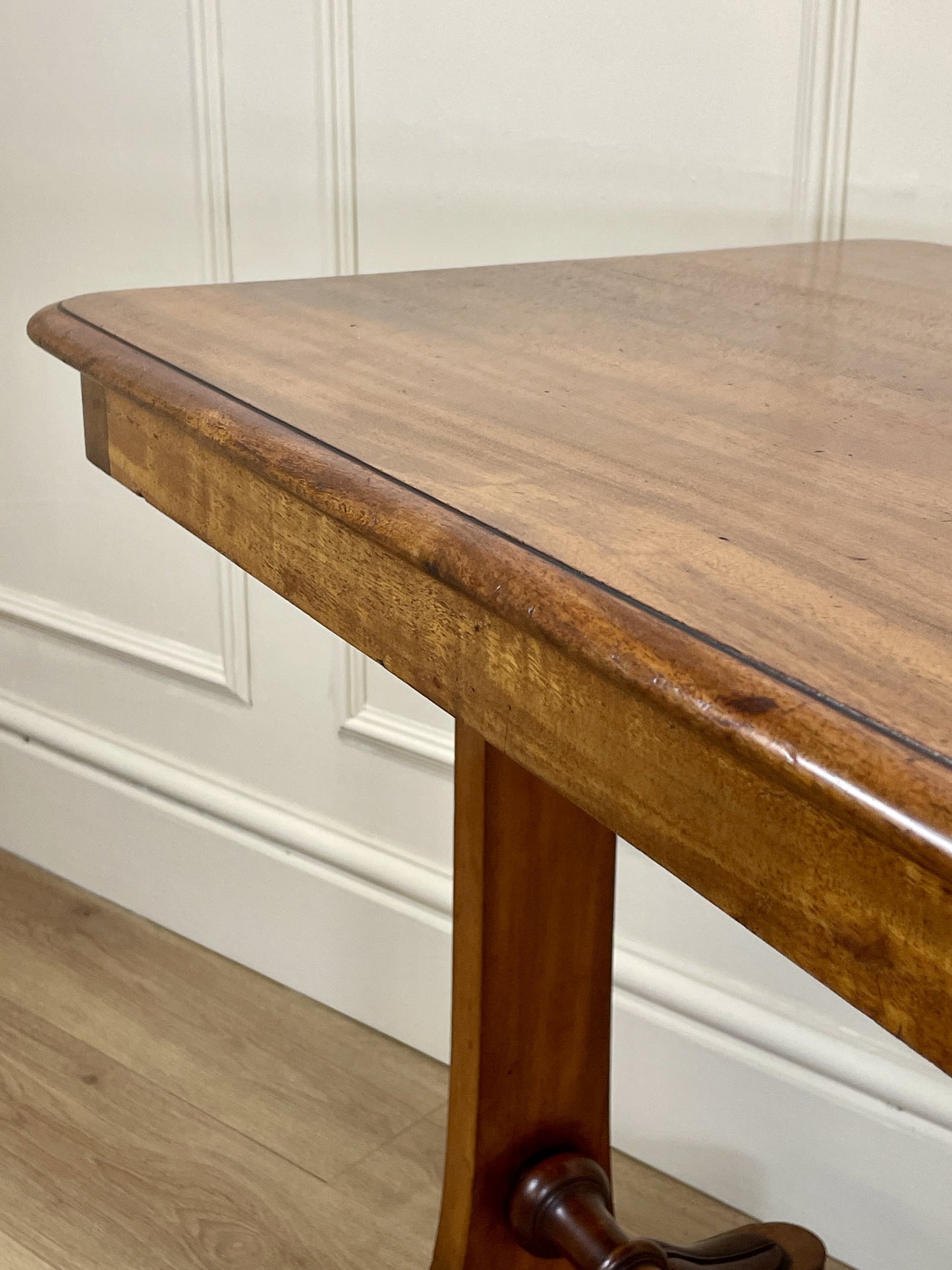 Wooden table against a white paneled wall