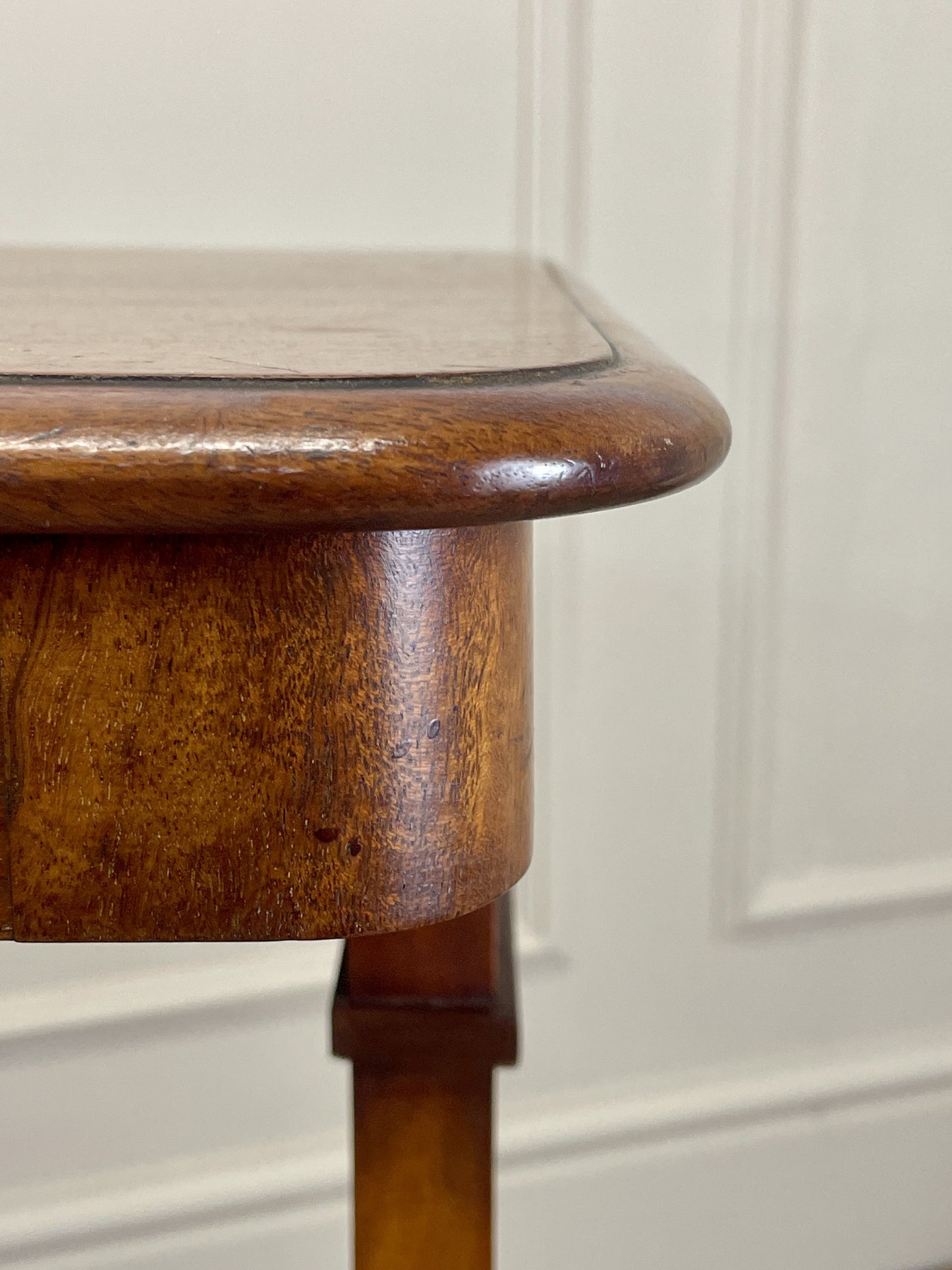 Wooden table corner with a white wall background