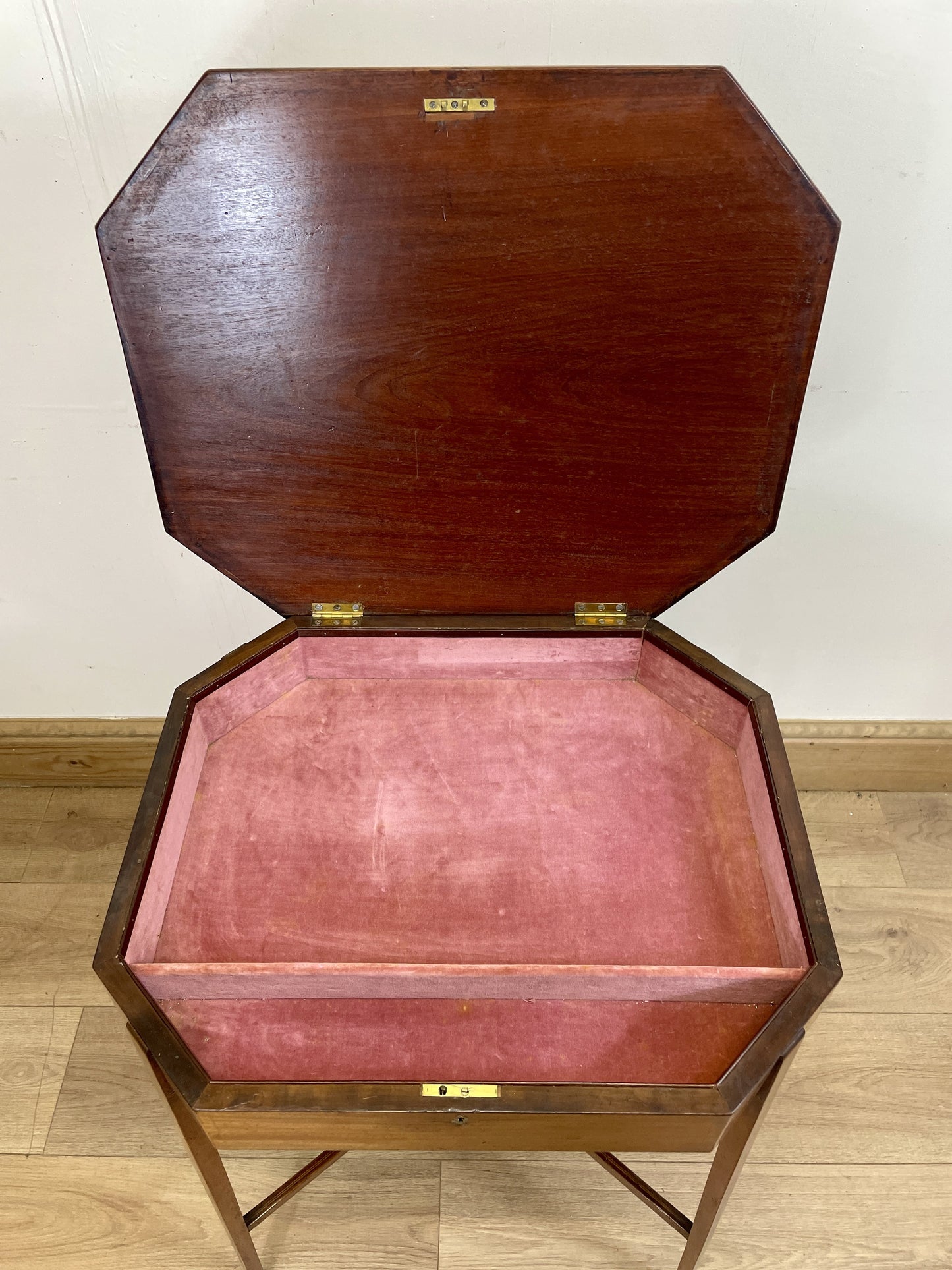Wooden jewelry box with pink interior on a wooden floor