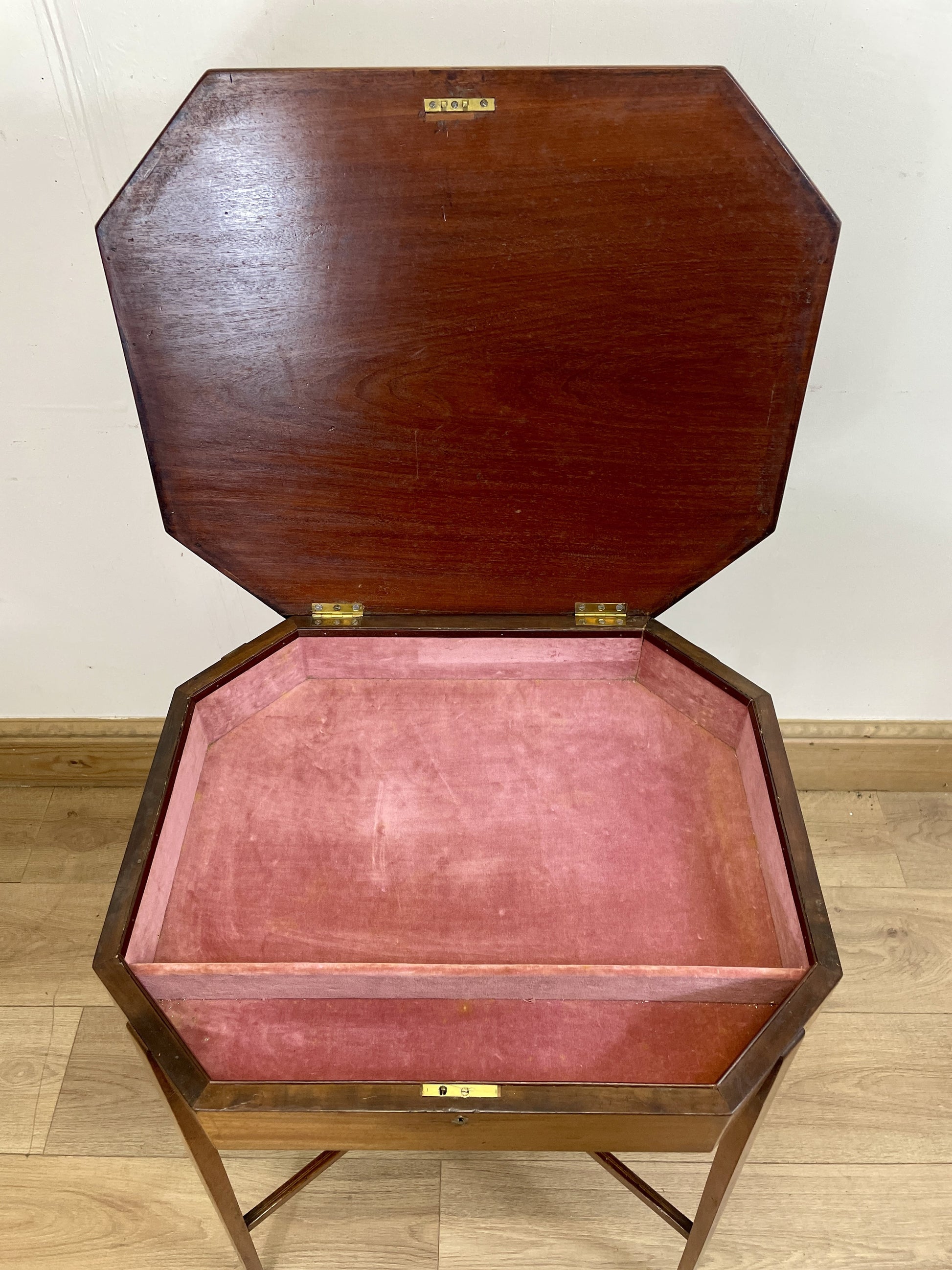 Wooden jewelry box with pink interior on a wooden floor