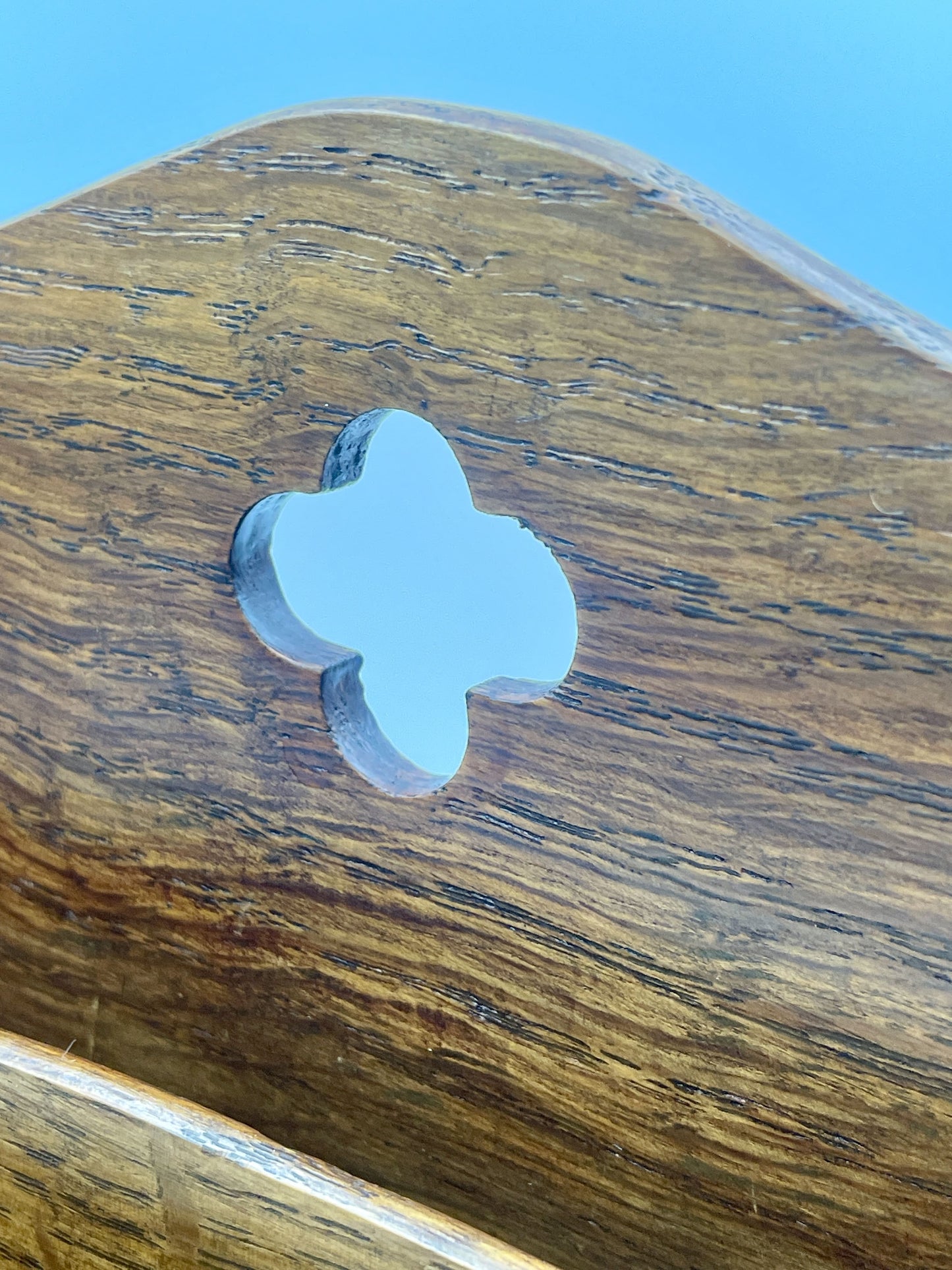 four-leaf clover charm on a wooden surface with a blue background