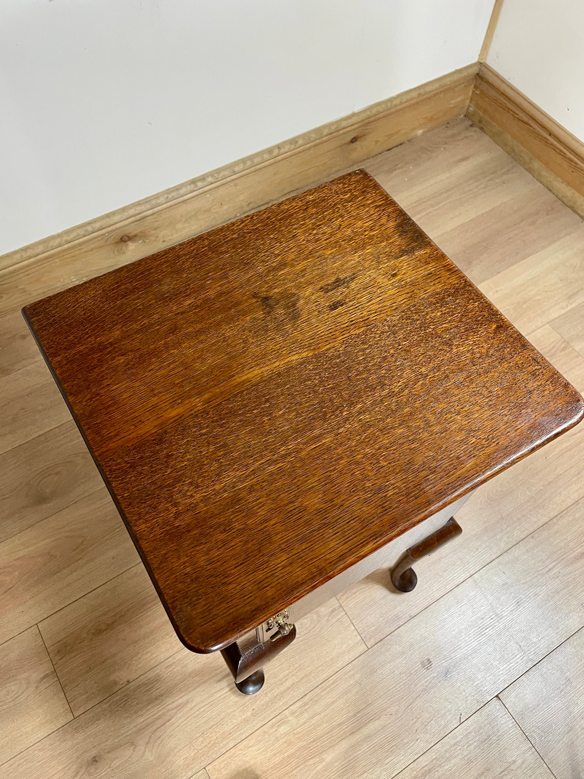Wooden nightstand with wheels on a wooden floor