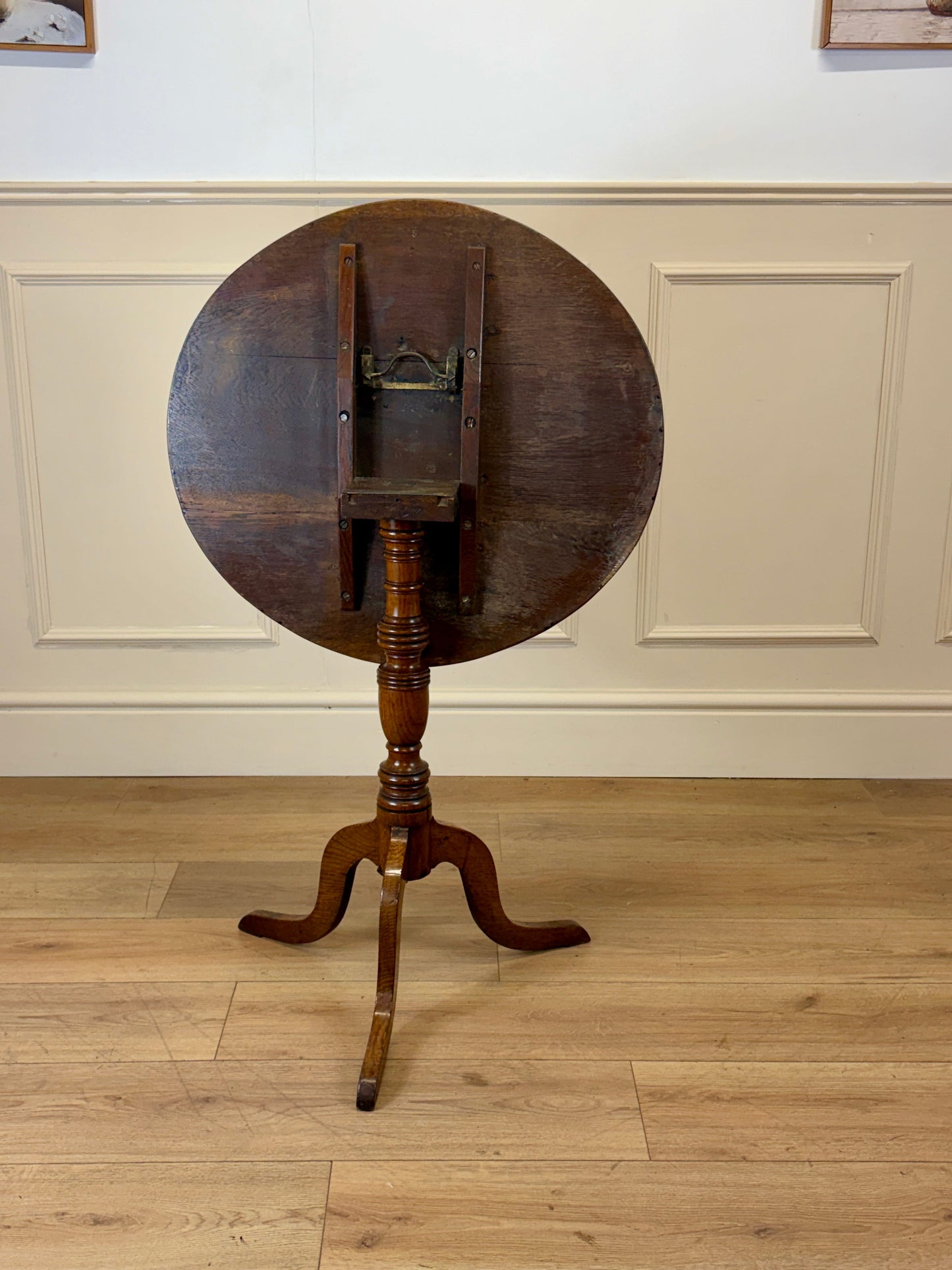 Antique Georgian oak tripod tilt-top table with oval top and tripod base in light oak finish.