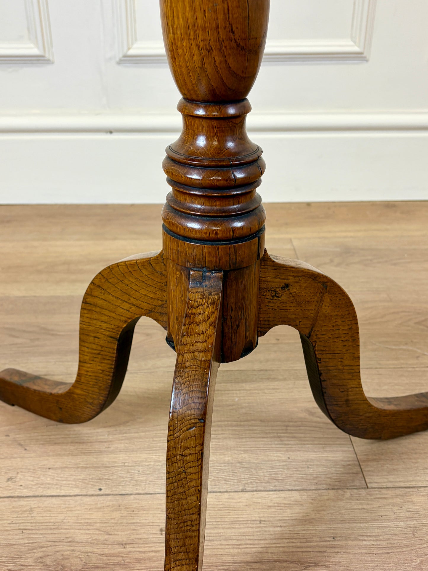 Antique Georgian oak tripod tilt-top table with oval top and tripod base in light oak finish.