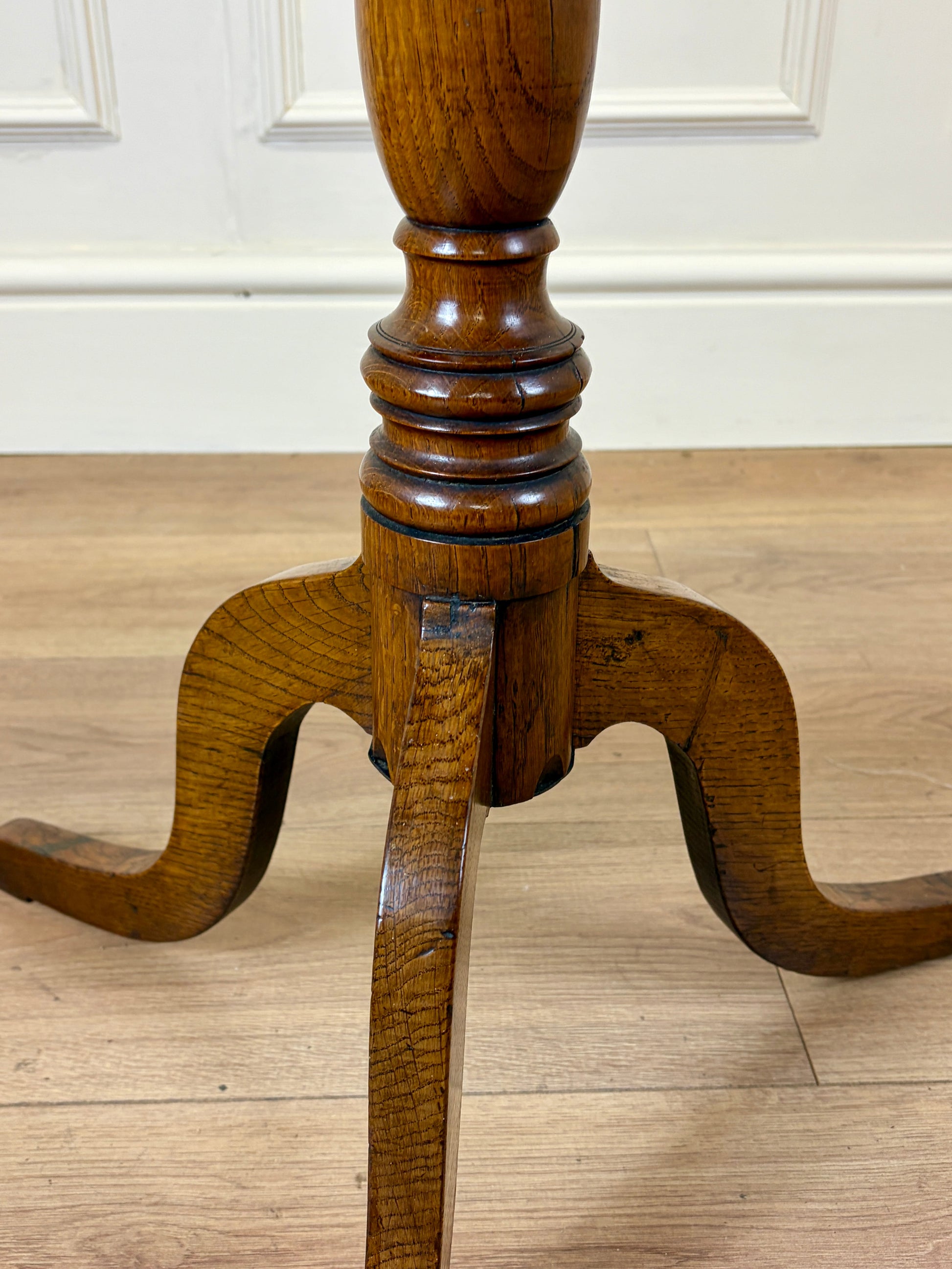 Antique Georgian oak tripod tilt-top table with oval top and tripod base in light oak finish.
