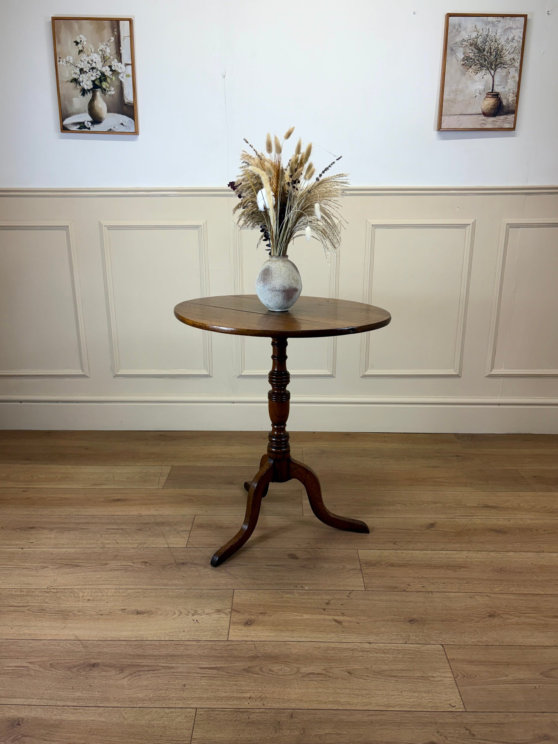 Antique Georgian oak tripod tilt-top table with oval top and tripod base in light oak finish.