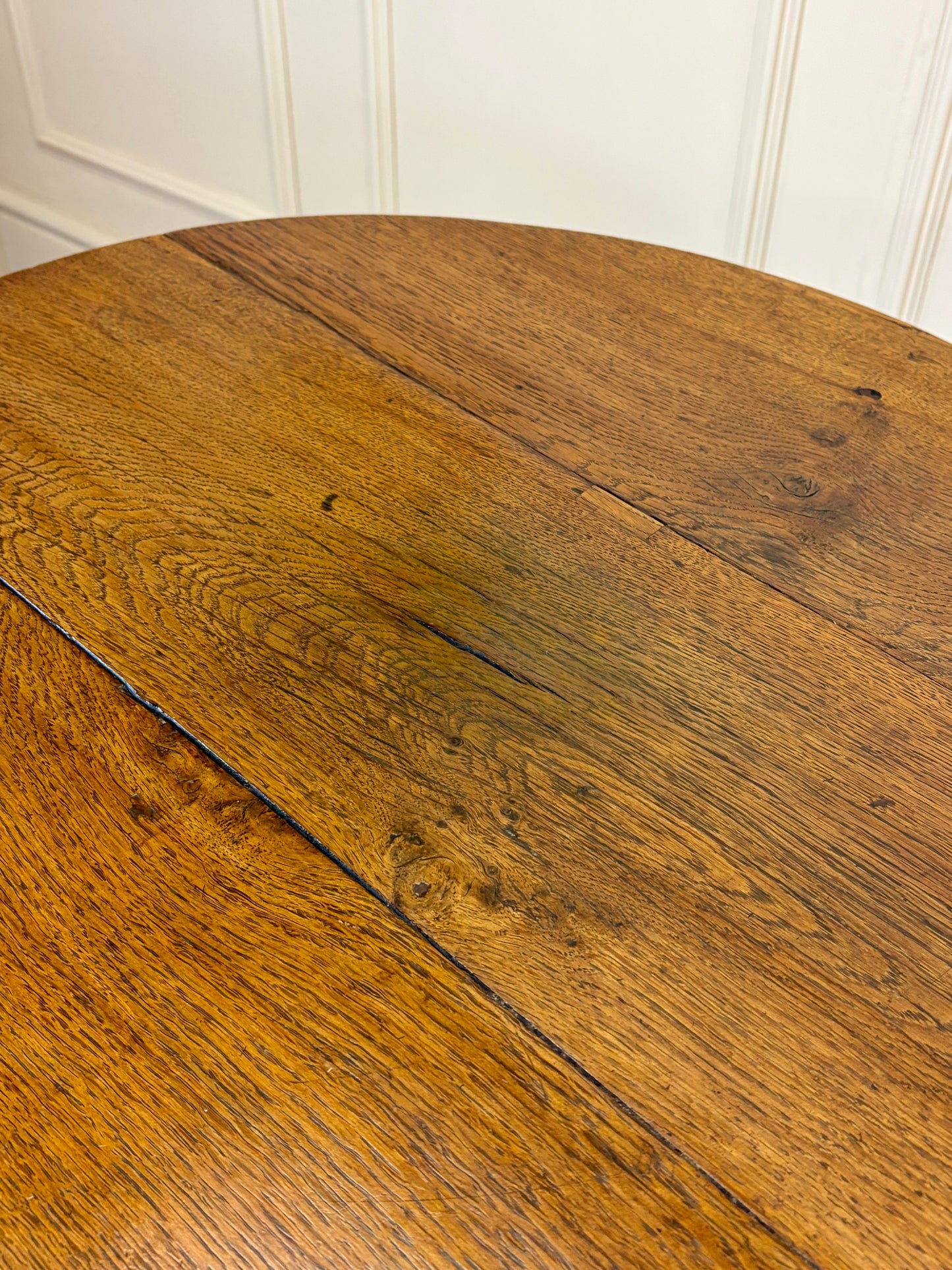 Antique Georgian oak tripod tilt-top table with oval top and tripod base in light oak finish.