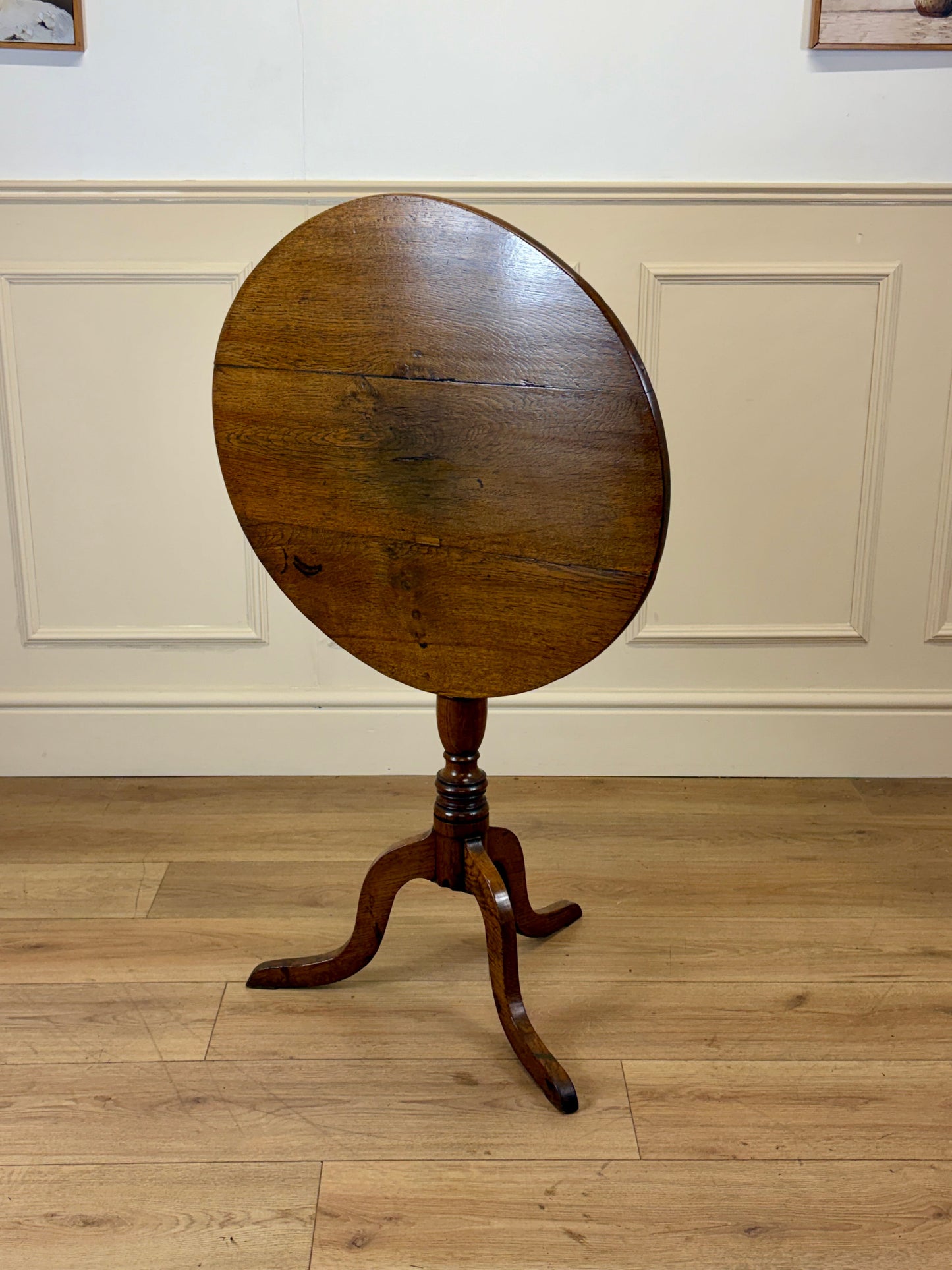 Antique Georgian oak tripod tilt-top table with oval top and tripod base in light oak finish.
