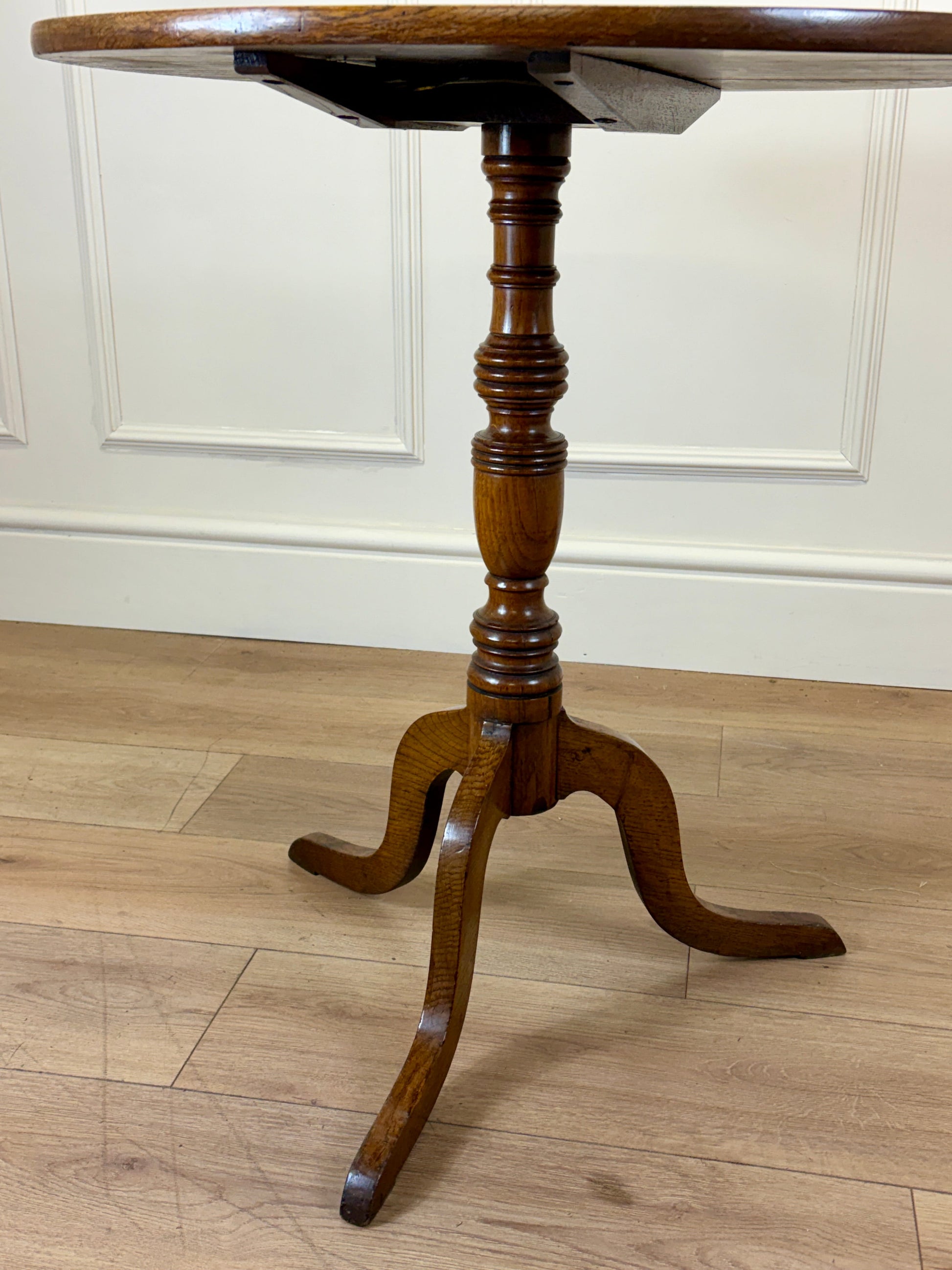 Antique Georgian oak tripod tilt-top table with oval top and tripod base in light oak finish.