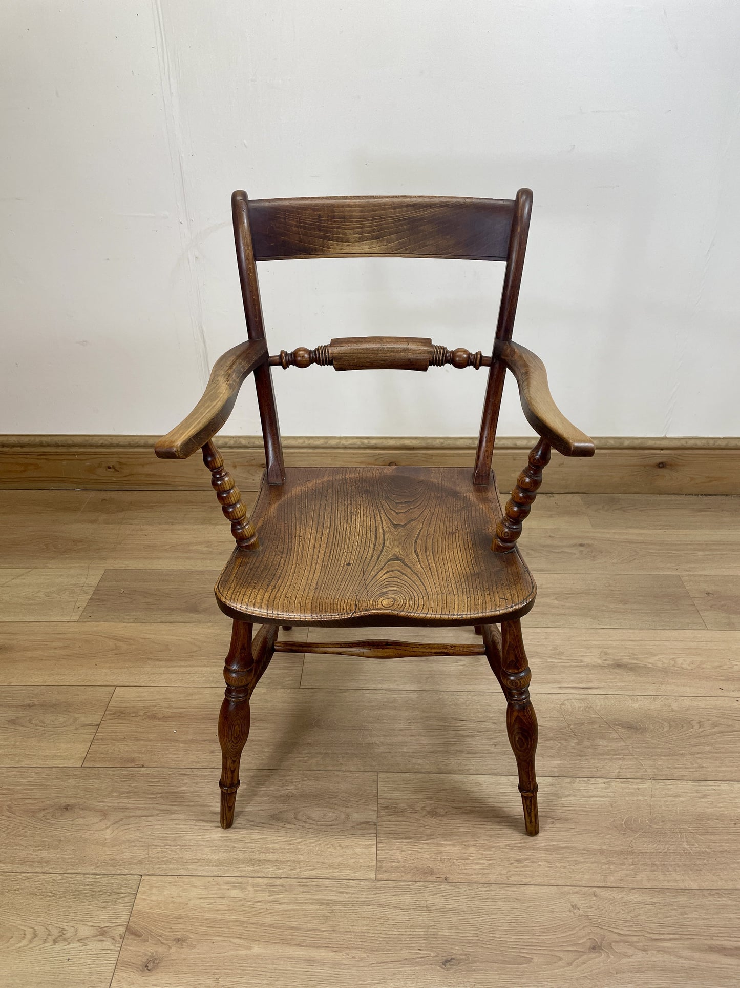 Wooden chair on a wooden floor with a white wall background
