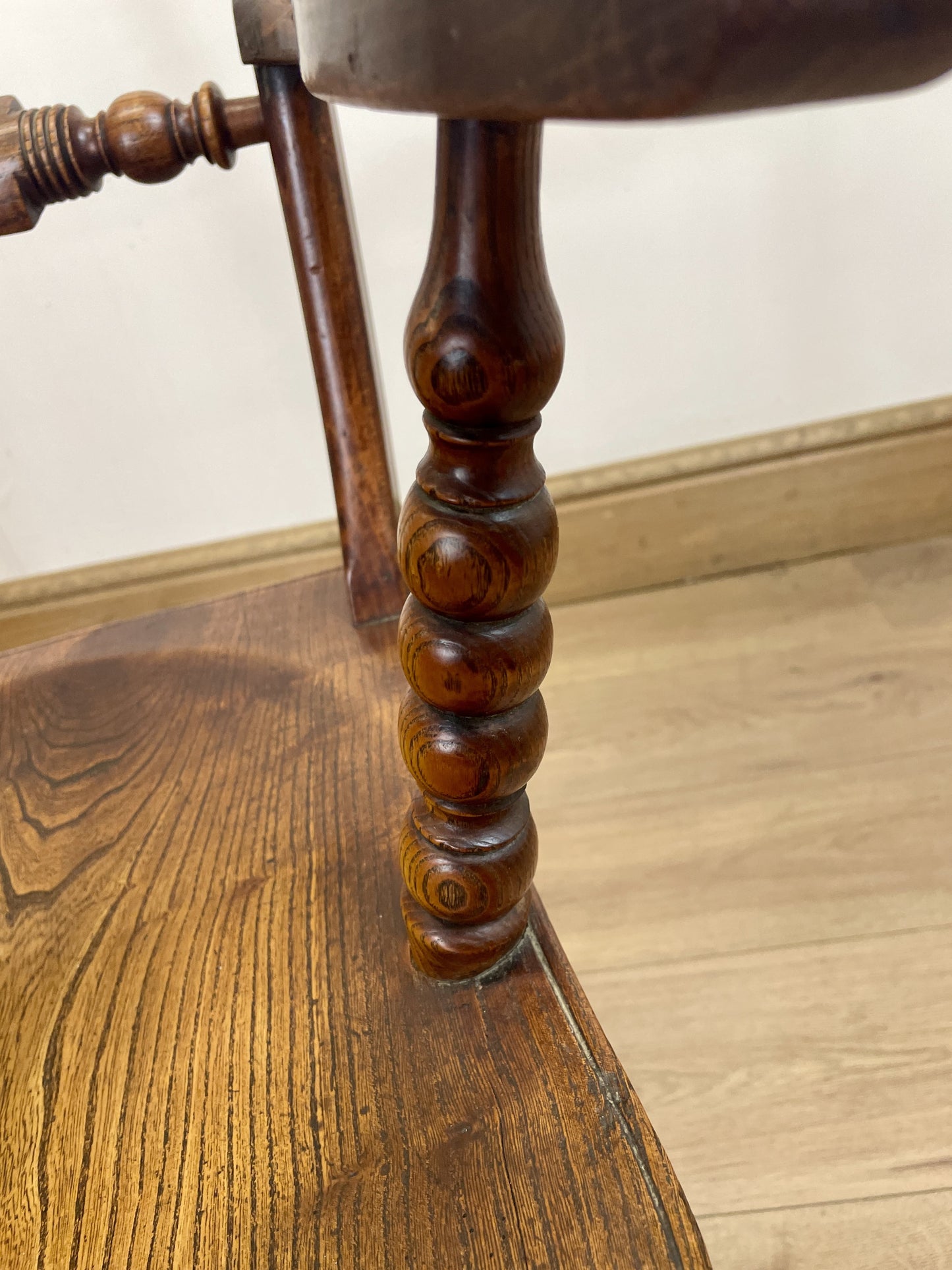 Close-up of a wooden chair with a spindle back and seat.