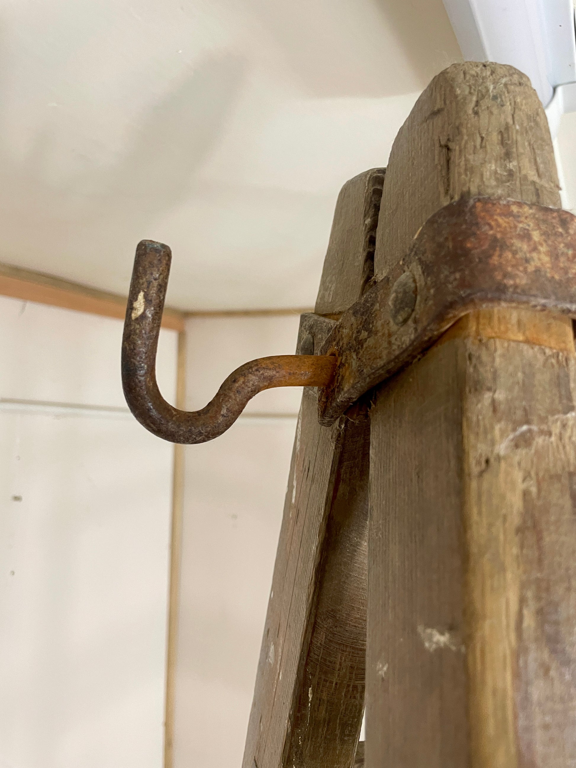 Rustic wooden hook with a metal hook on a wooden surface.