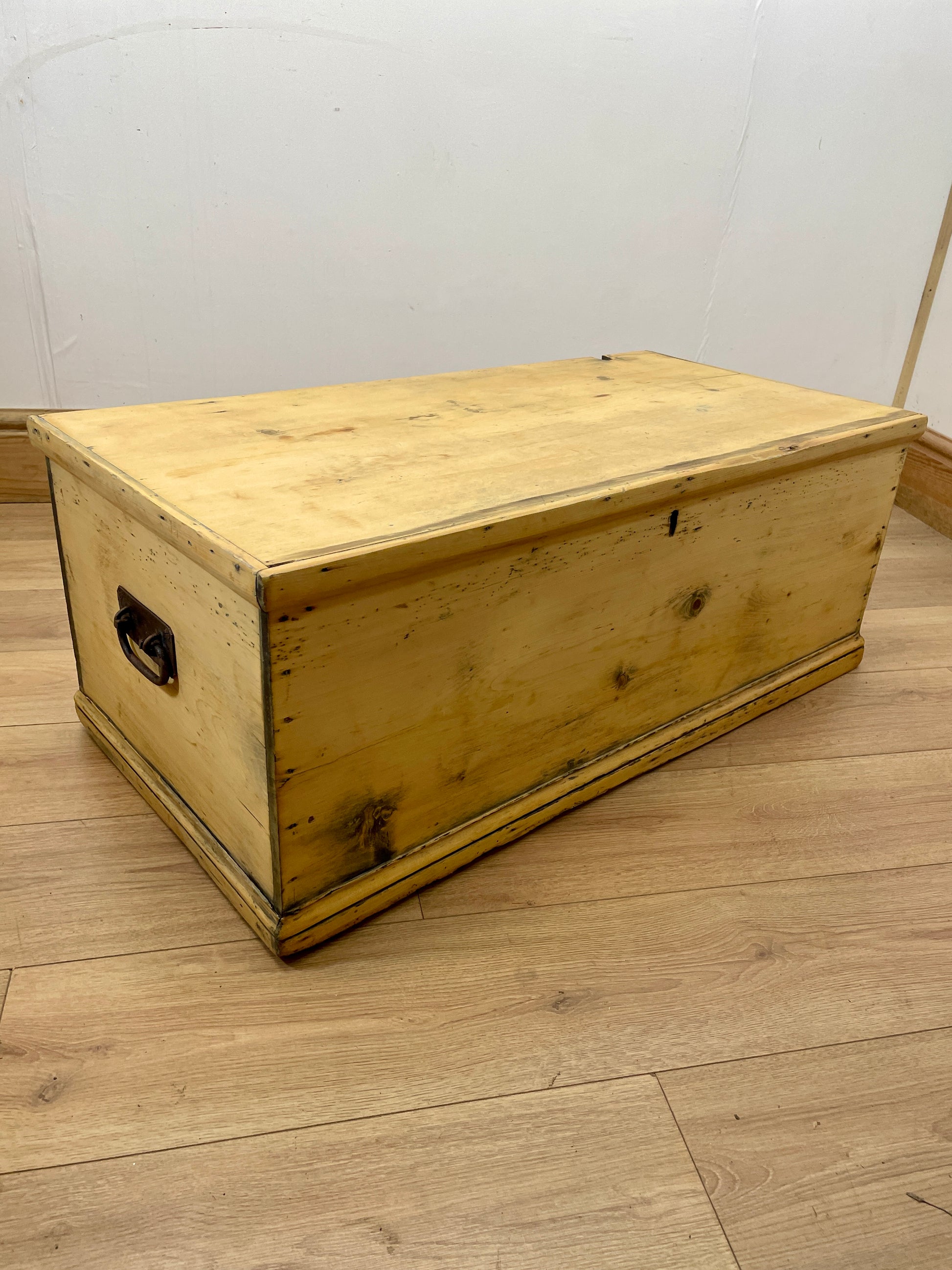 Wooden chest on a wooden floor with a white wall background