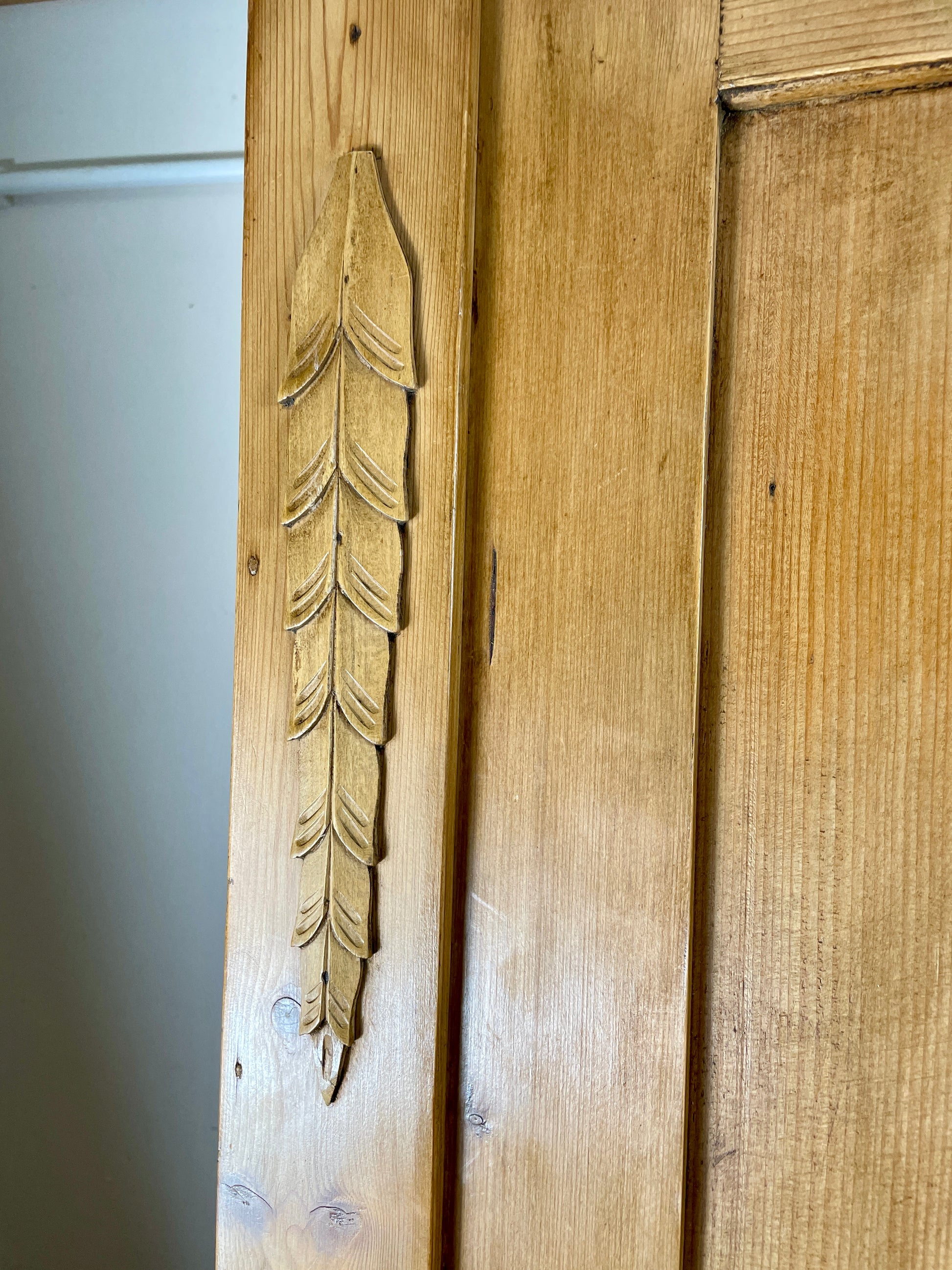 Wooden door with a carved feather design