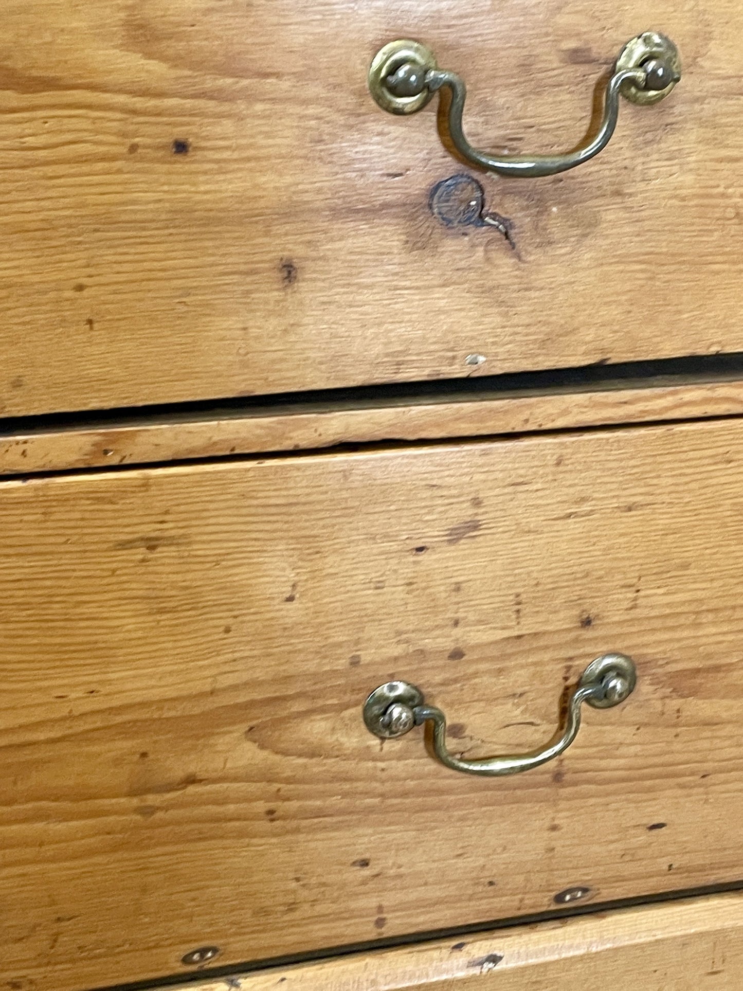 Wooden drawer with metal handles showing signs of wear.