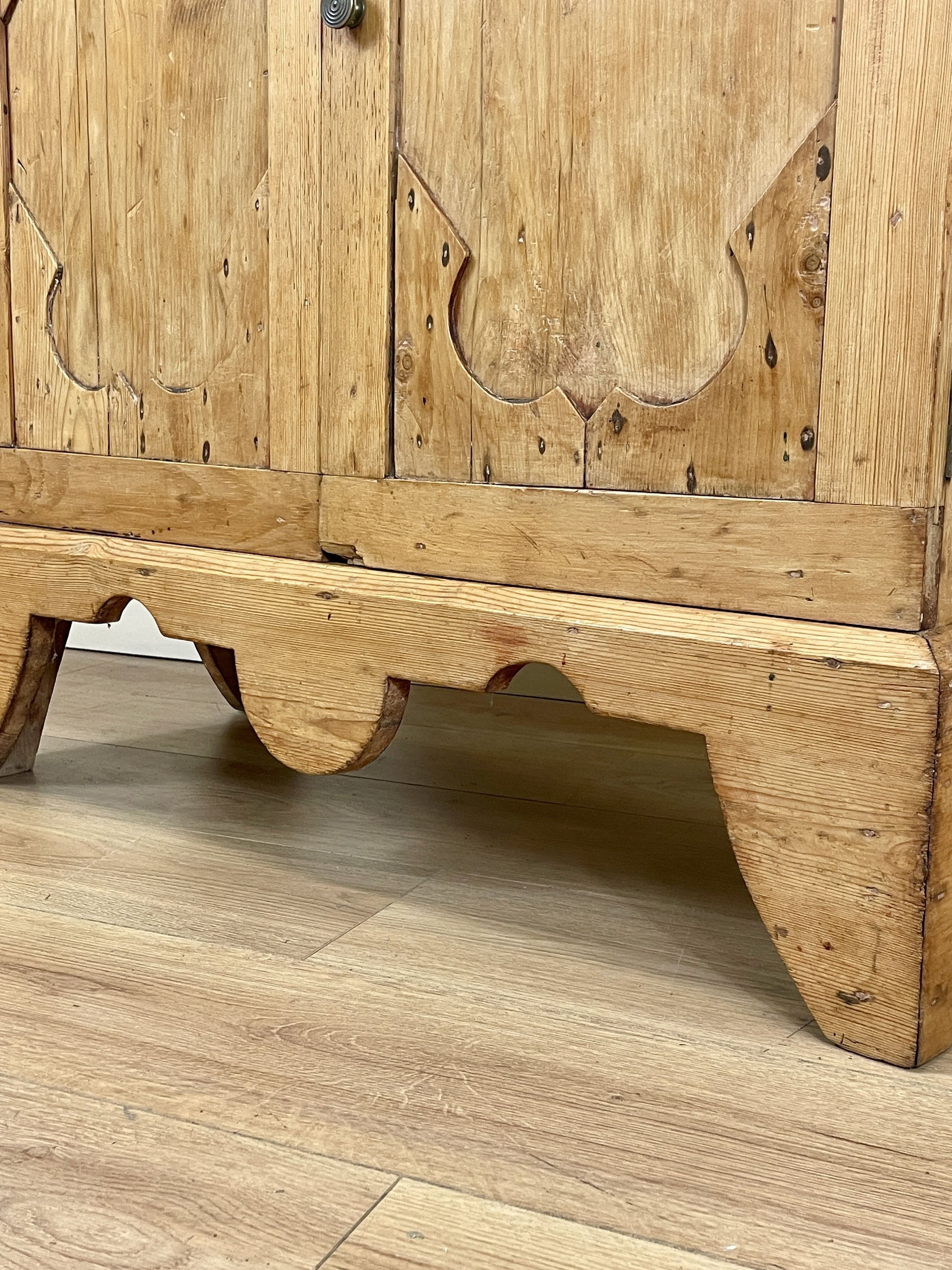 Wooden cabinet with intricate carvings on a wooden floor