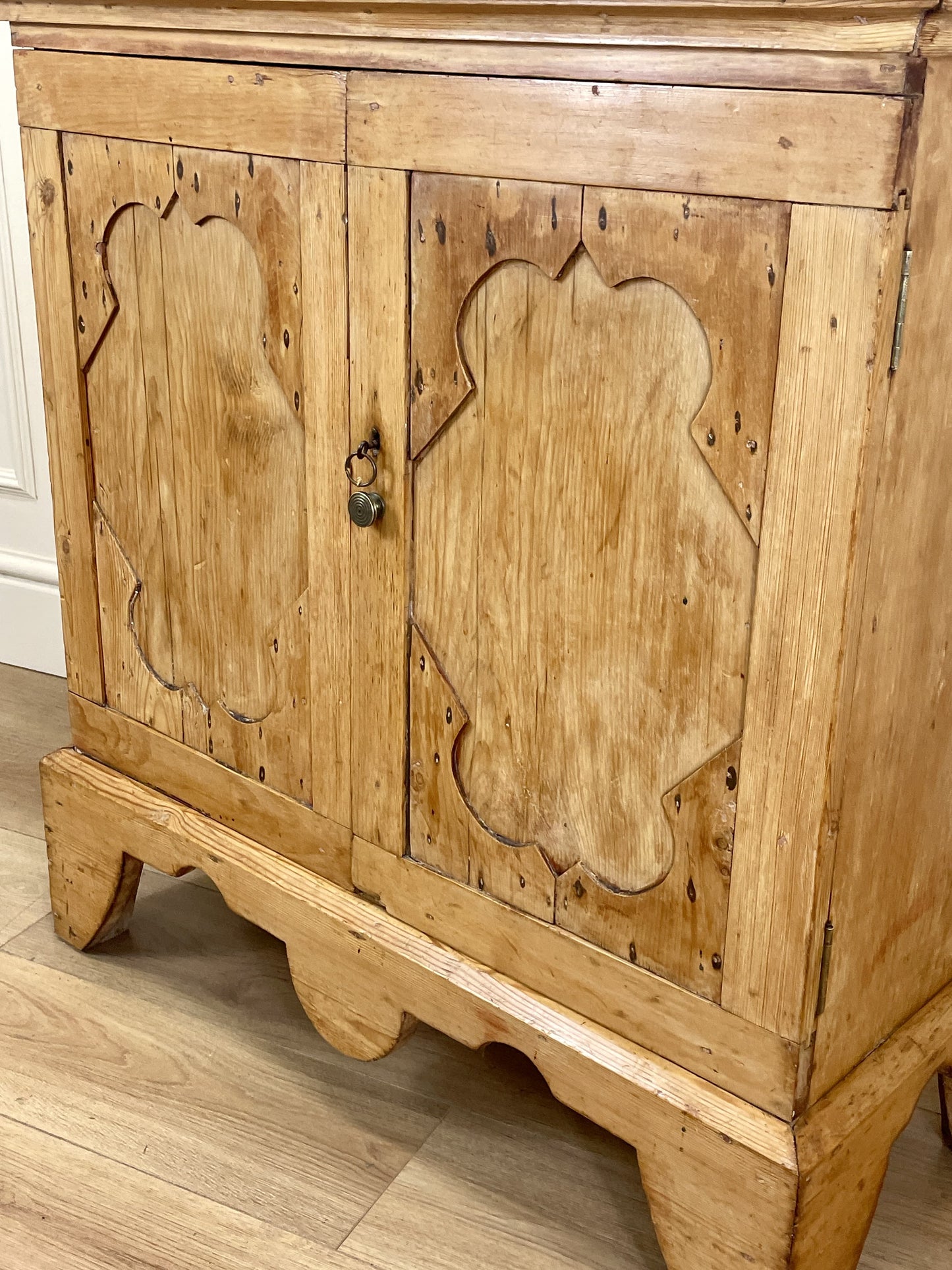 Wooden cabinet with decorative carvings on a wooden floor
