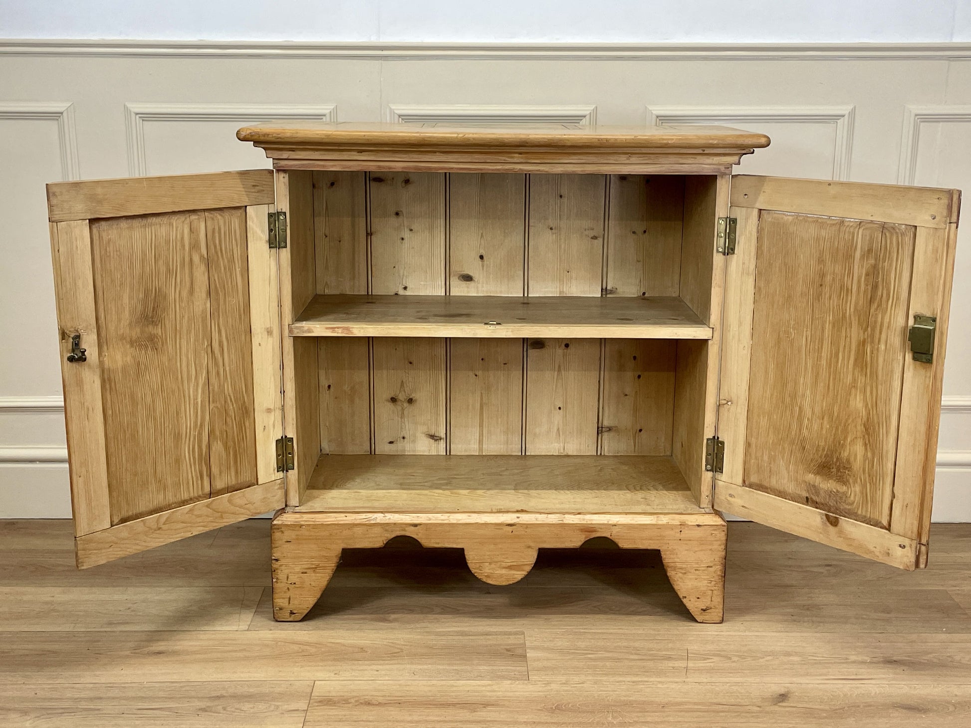 Wooden cabinet with open doors on a wooden floor.