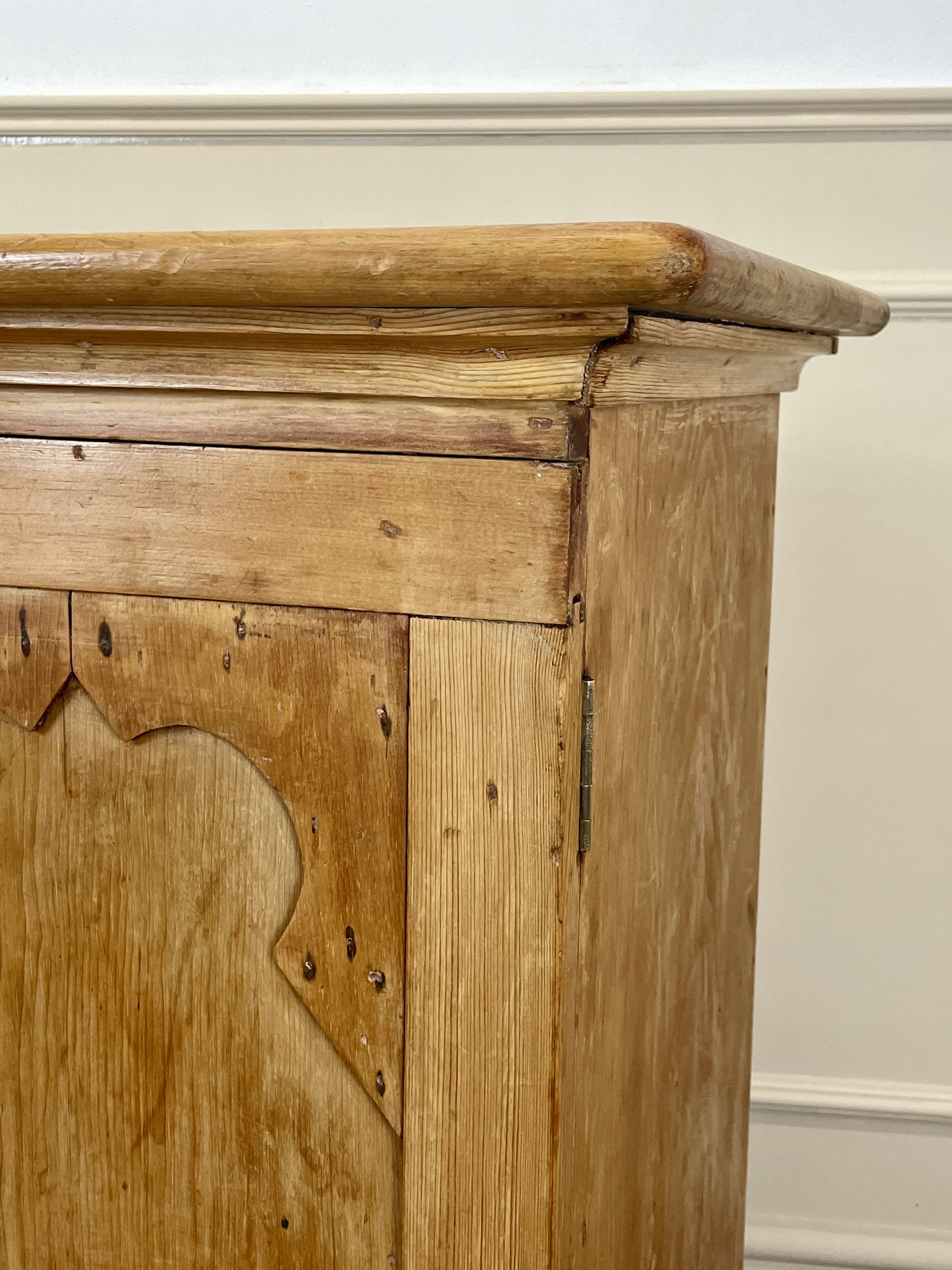 Vintage wooden cabinet with intricate carvings on a white wall background