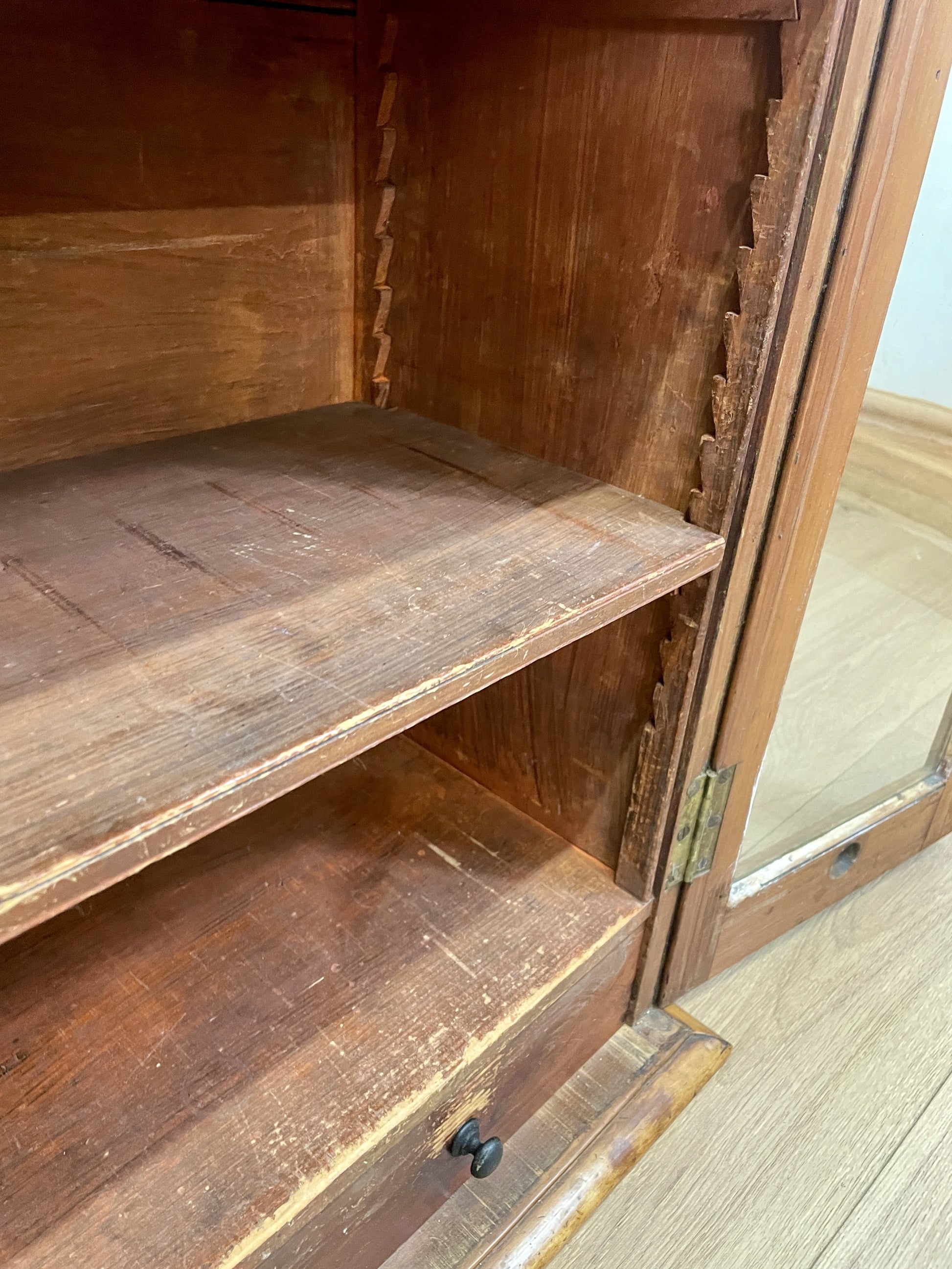 Wooden cabinet with glass door on a wooden floor