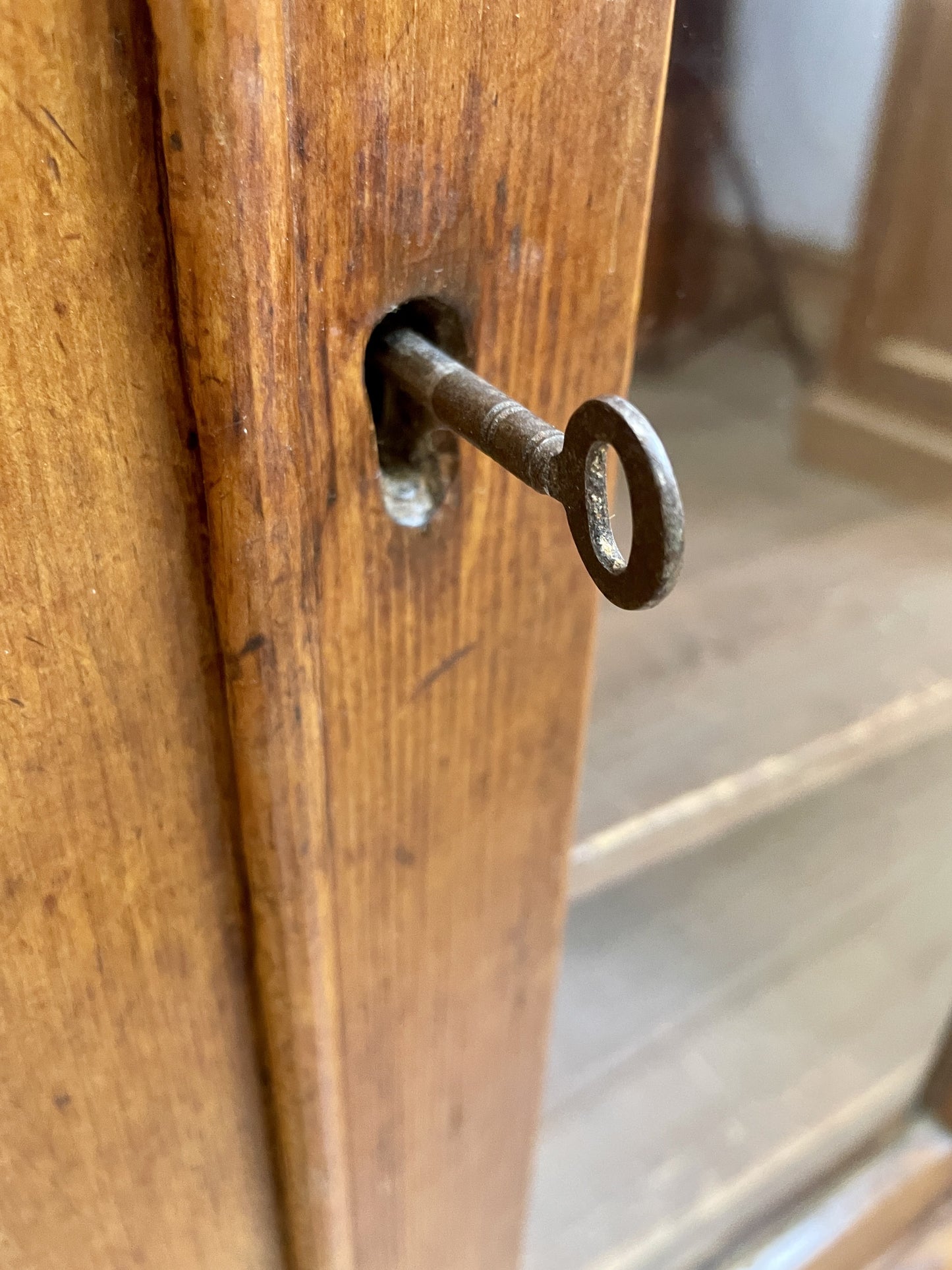 Keyhole with a key inserted in a wooden door