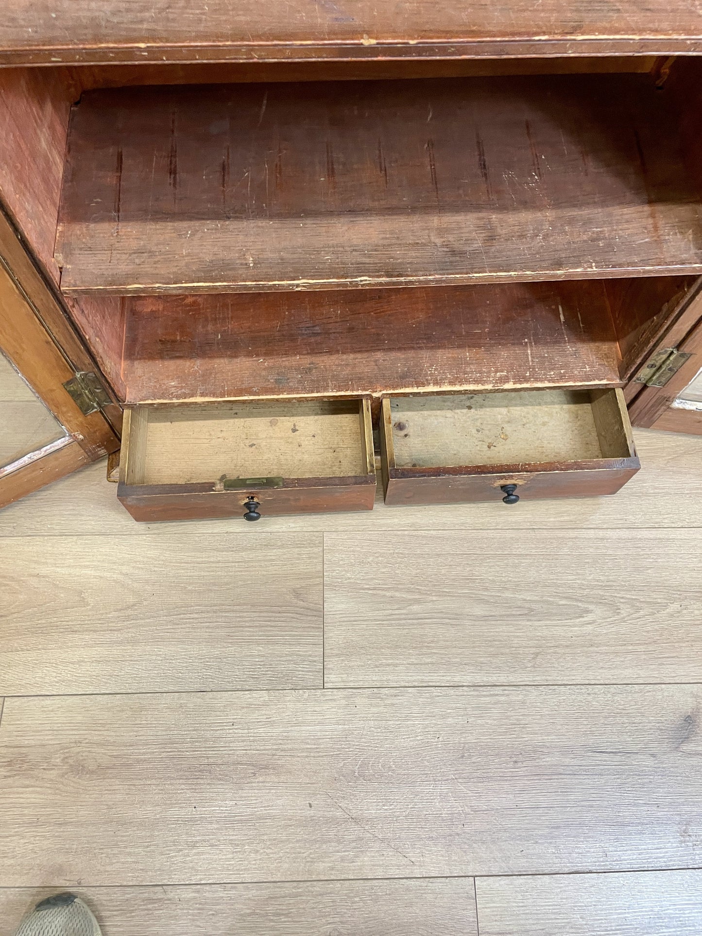 Wooden cabinet with open drawers on a wooden floor