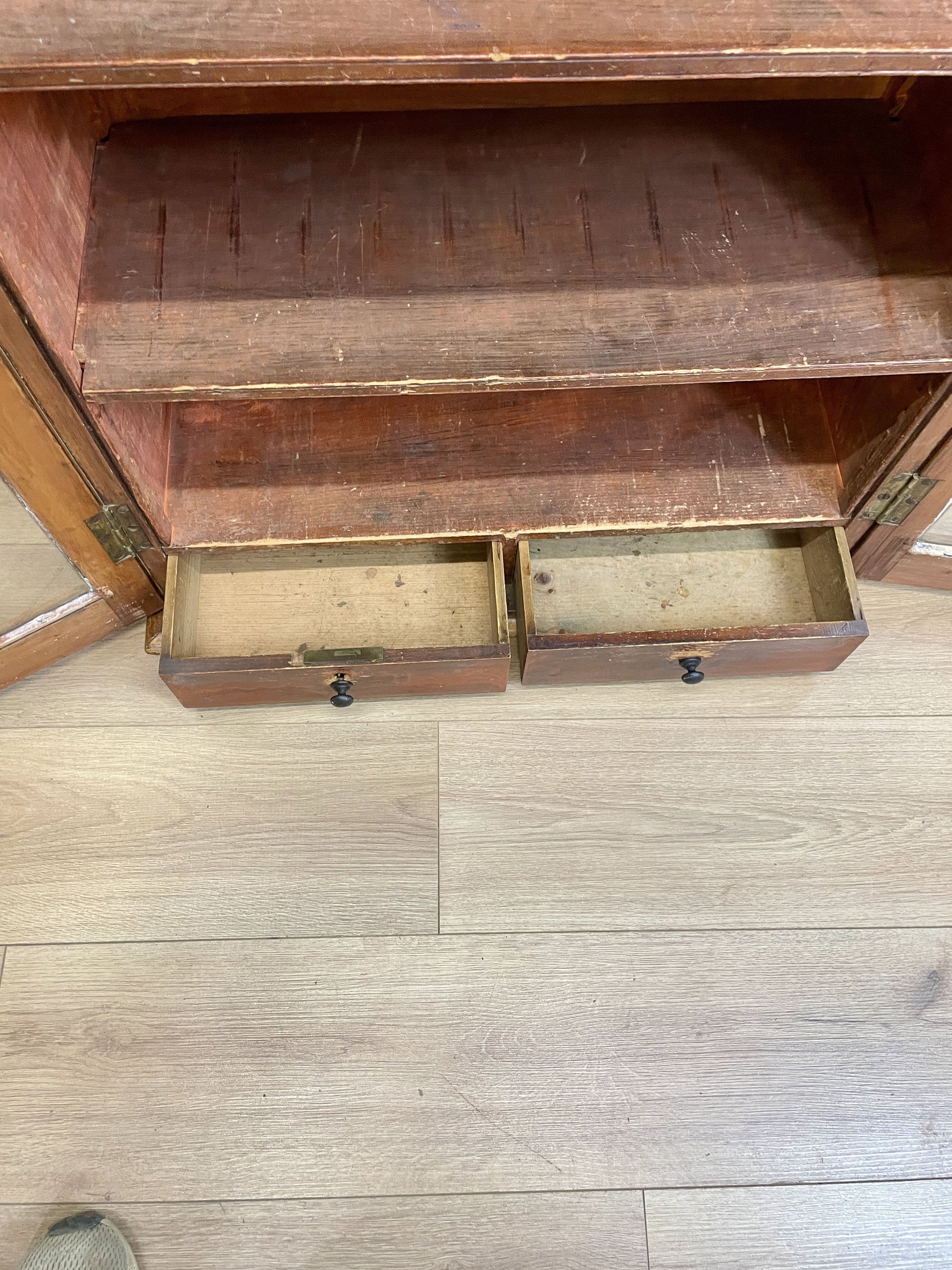 Wooden cabinet with open drawers on a wooden floor