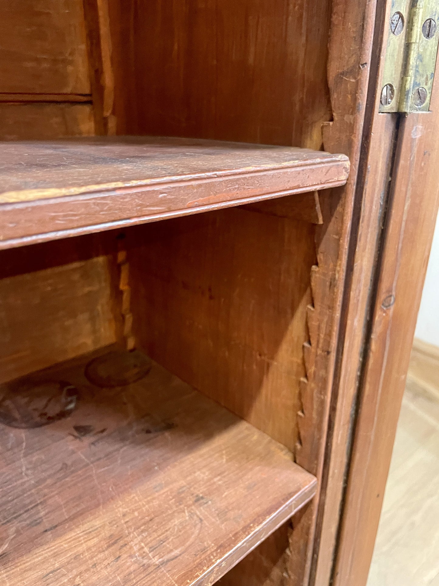 Wooden cabinet with two shelves and a visible hinge.