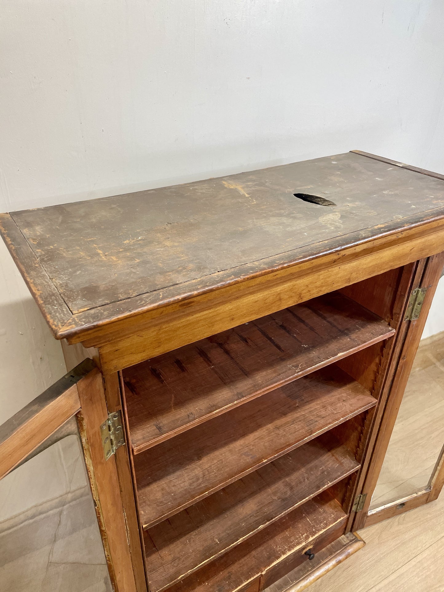 Wooden cabinet with a metal top on a tiled floor.