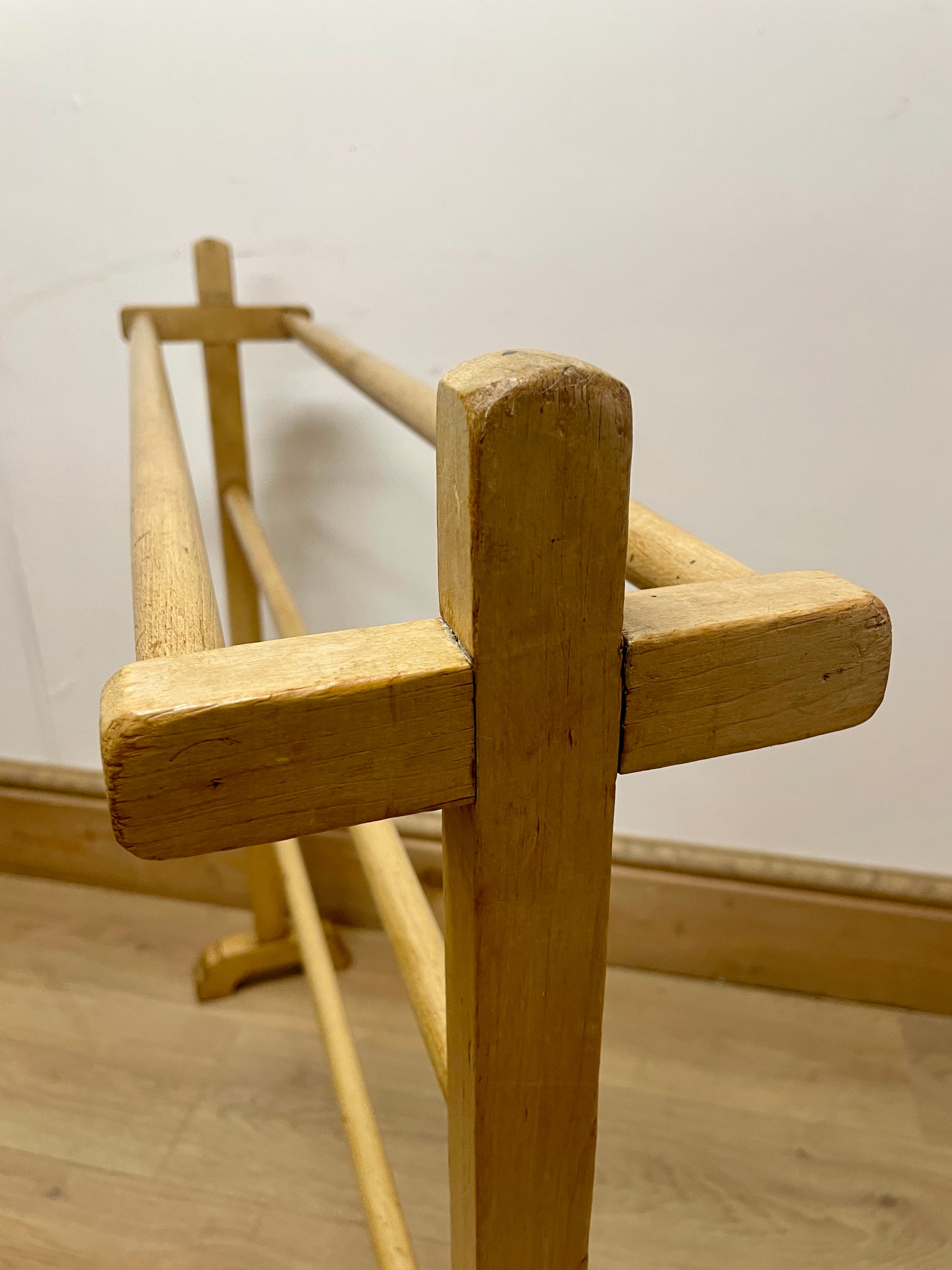 Wooden loom on a wooden floor with a plain wall background