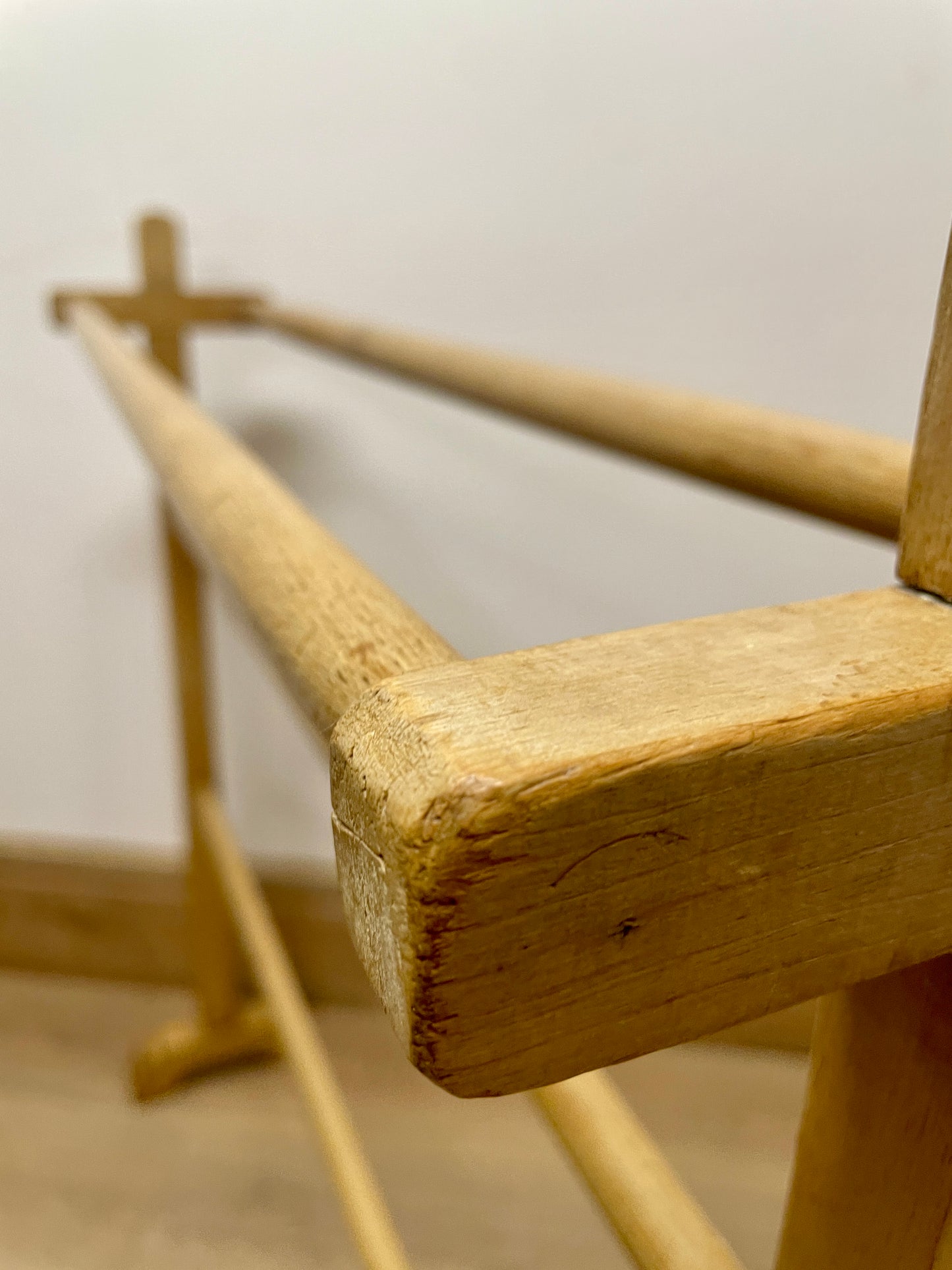 Close-up of a wooden ballet barre against a plain wall.