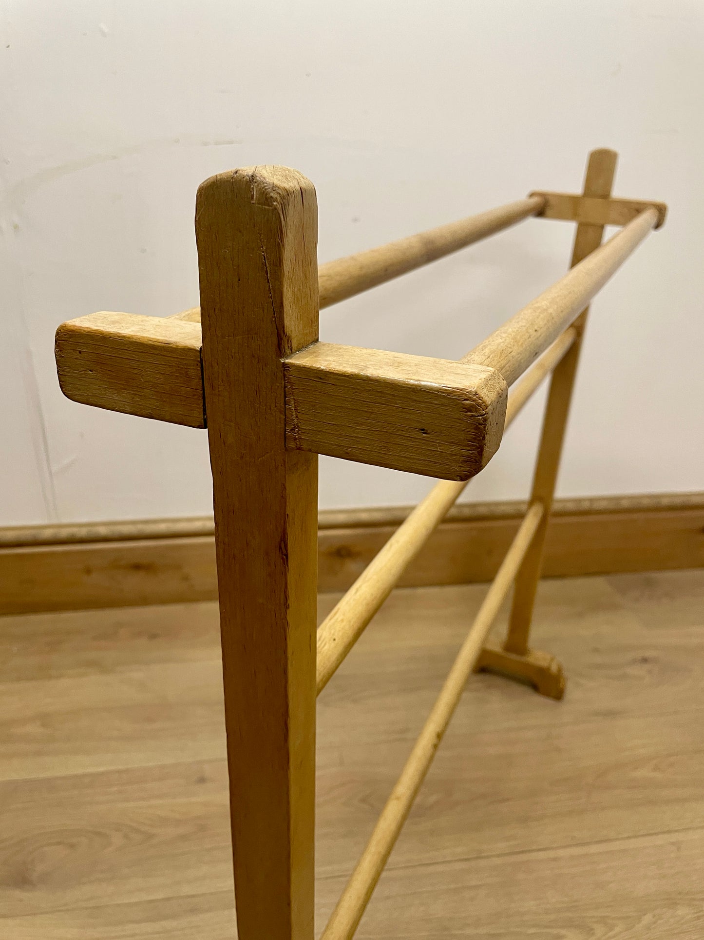 Wooden garment rack against a white wall