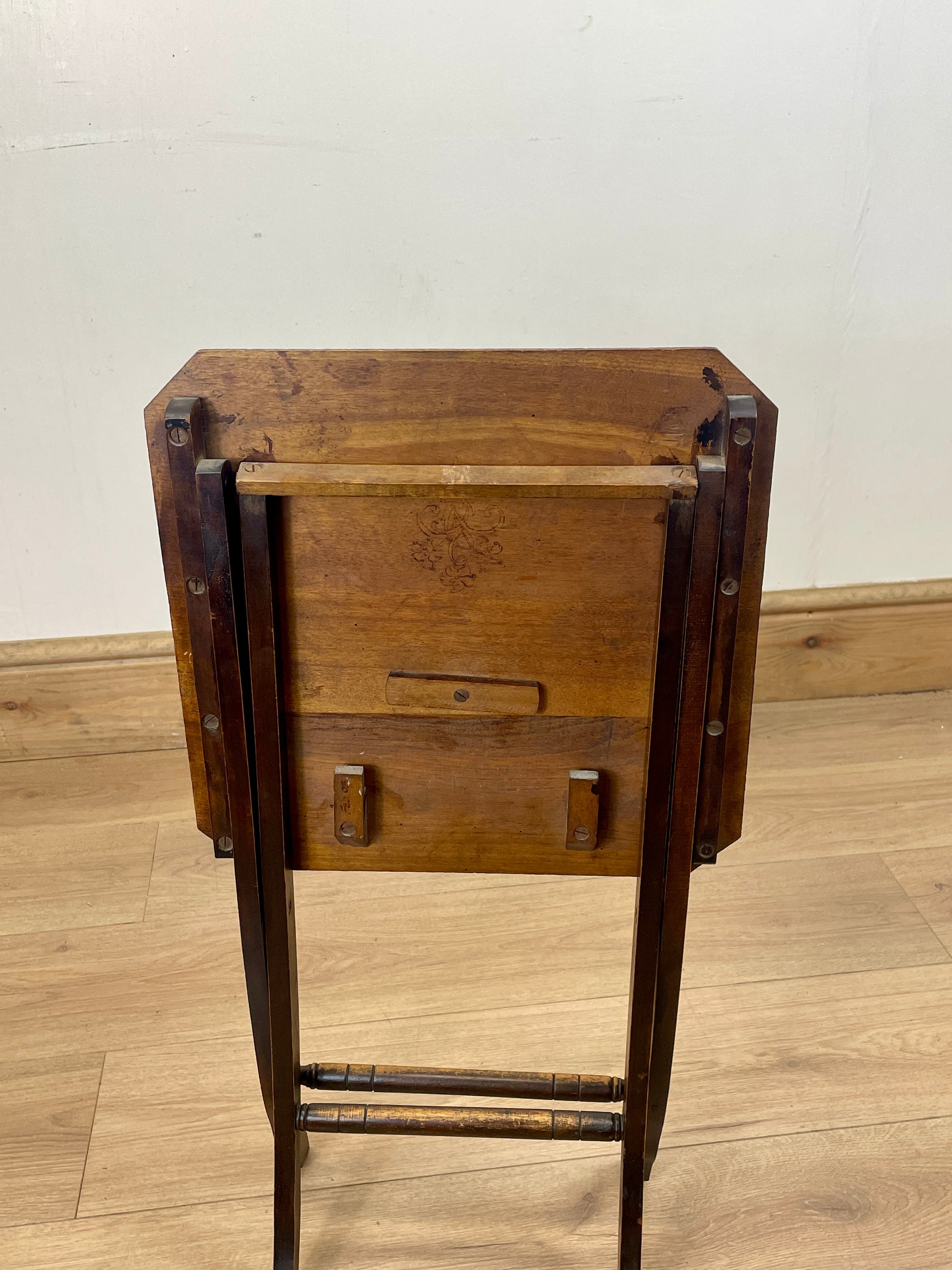 Wooden side table with metal accents on a wooden floor.