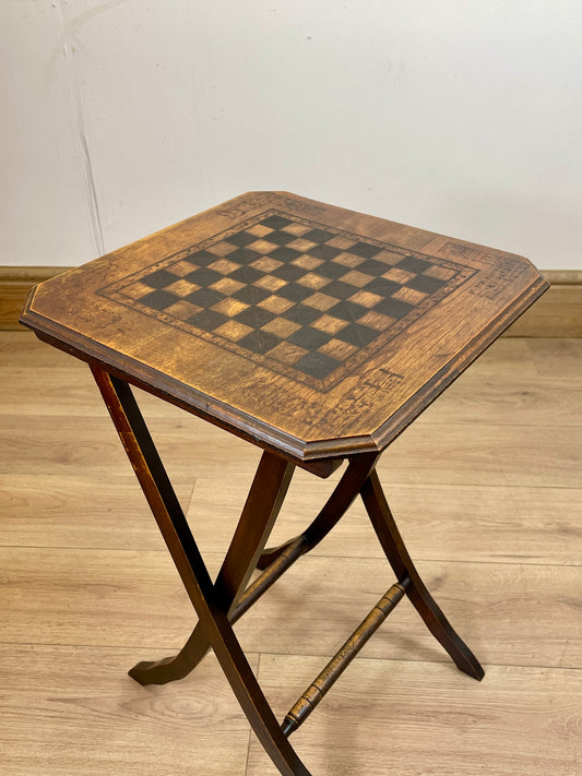 Hexagonal wooden table with checkered surface on a wooden floor.