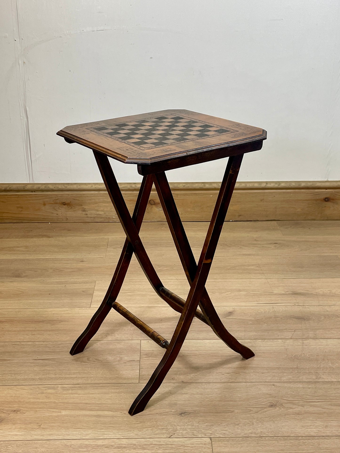 Wooden side table with checkered surface on a wooden floor